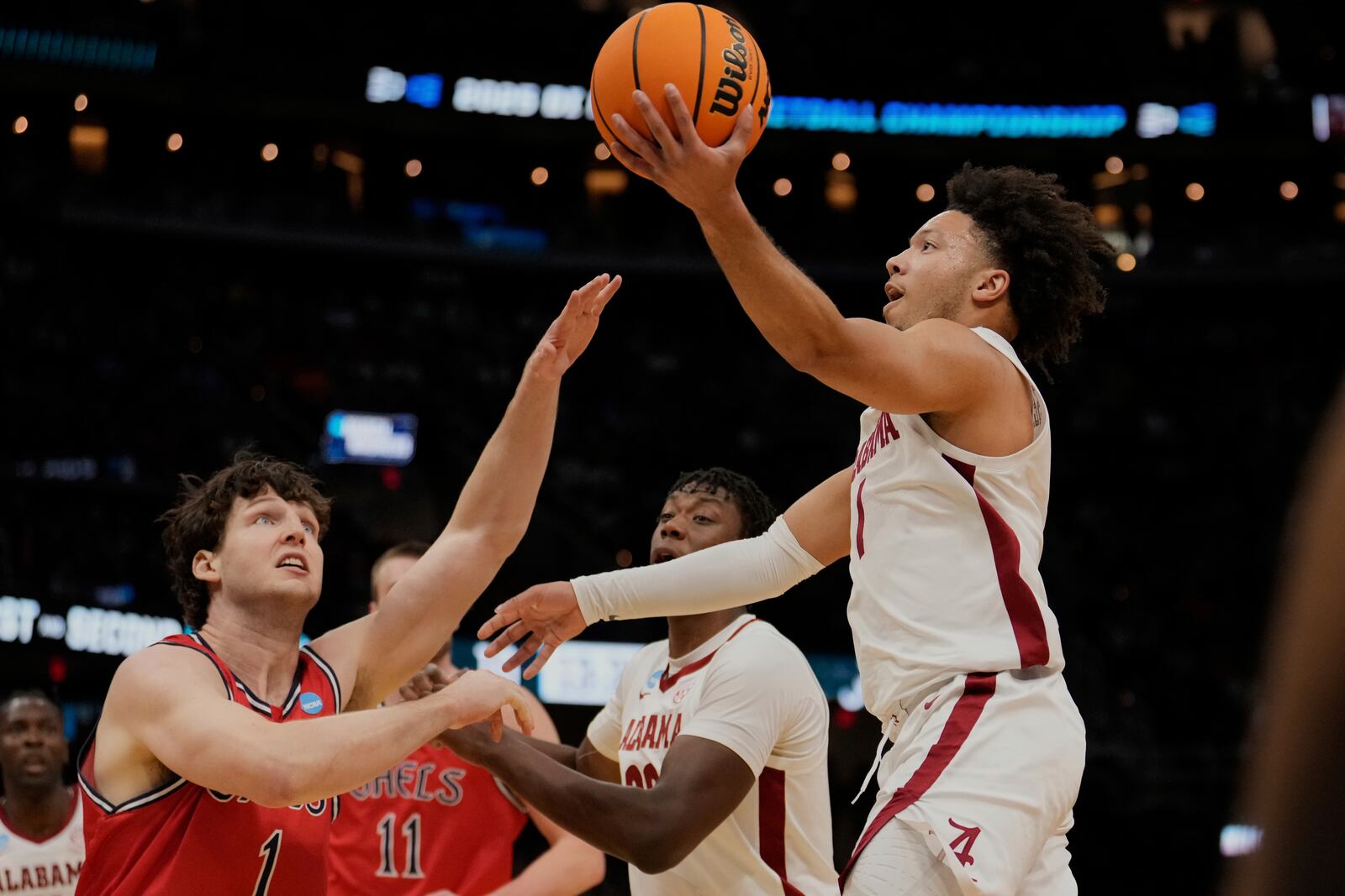 Alabama guard Mark Sears, right, shoots in front of Saint Mary's center Harry Wessels, left, in the first half in the second round of the NCAA college basketball tournament, Sunday, March 23, 2025, in Cleveland. (AP Photo/Sue Ogrocki)