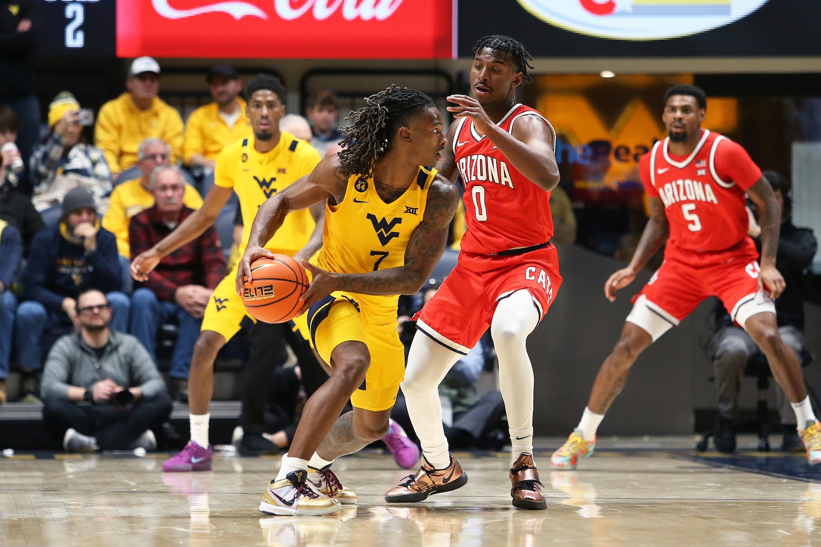 West Virginia guard Javon Small (7) is defended by Arizona guard Jaden Bradley (0) during the second half of an NCAA college basketball game, Tuesday, Jan. 7, 2025, in Morgantown, W.Va. (AP Photo/Kathleen Batten)