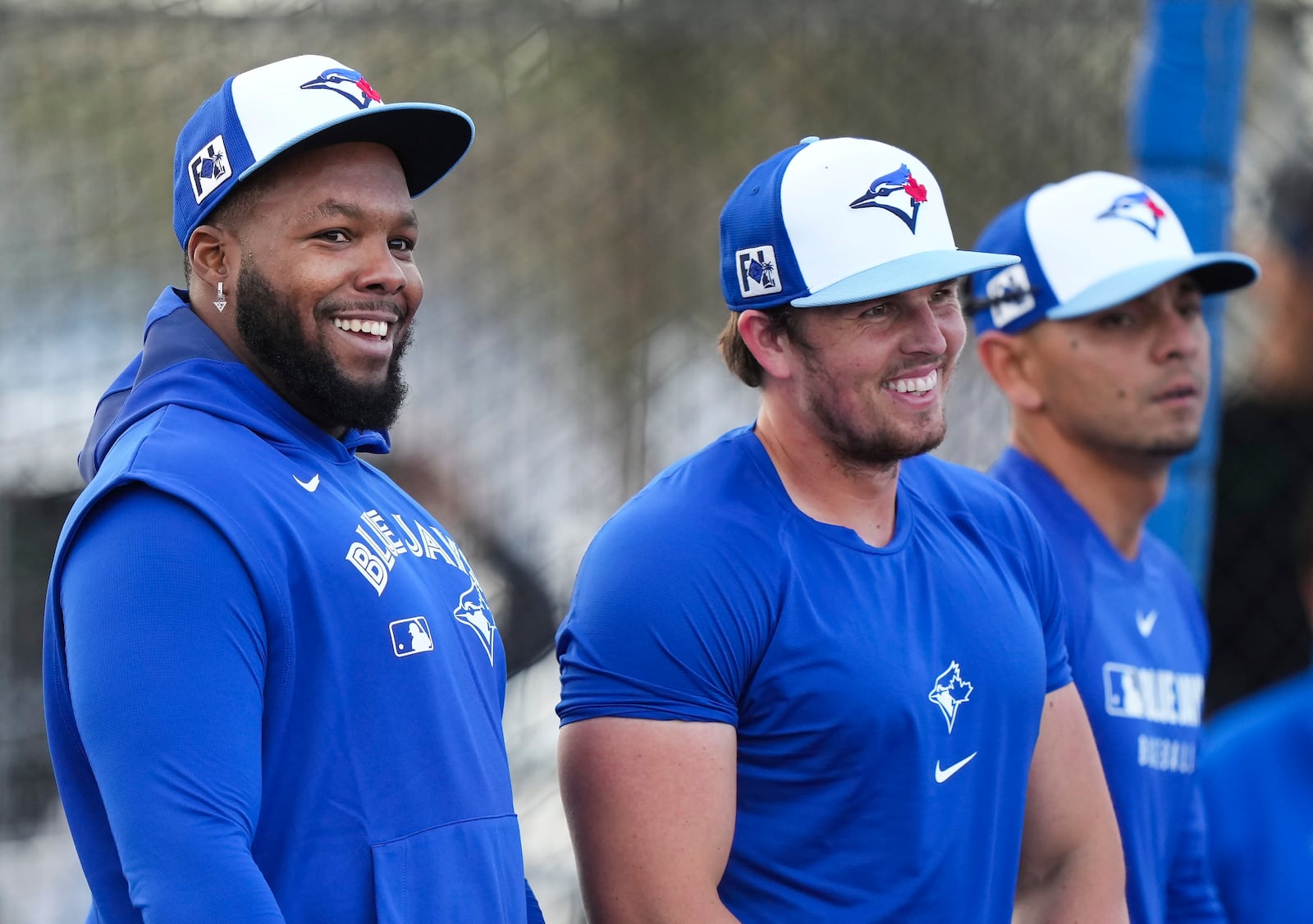 Toronto Blue Jays first baseman Vladimir Guerrero Jr., left, laughs with teammates during spring training baseball workouts in Dunedin Fla., Tuesday, Feb. 18, 2025. (Nathan Denette/The Canadian Press via AP)