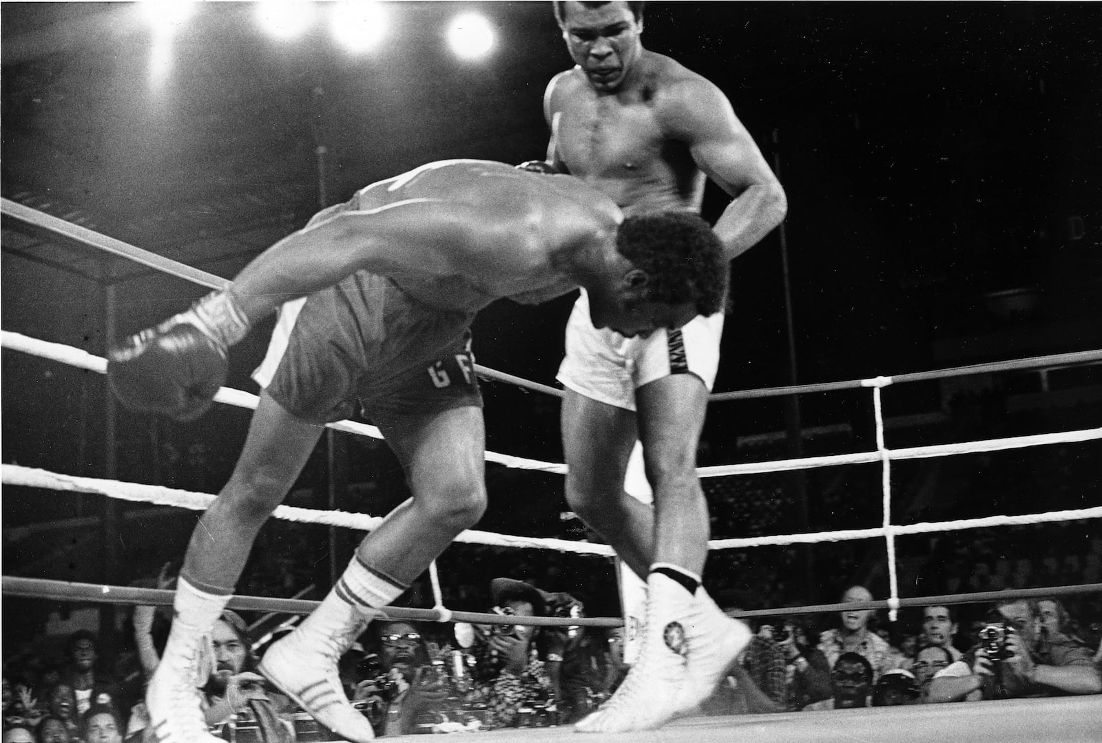 FILE - Challenger Muhammad Ali, right, watches as defending world champion George Foreman goes down to the canvas in the eighth round of their WBA/WBC championship match, on Oct. 30, 1974, in Kinshasa, Zaire. (AP Photo/Richard Drew, File)