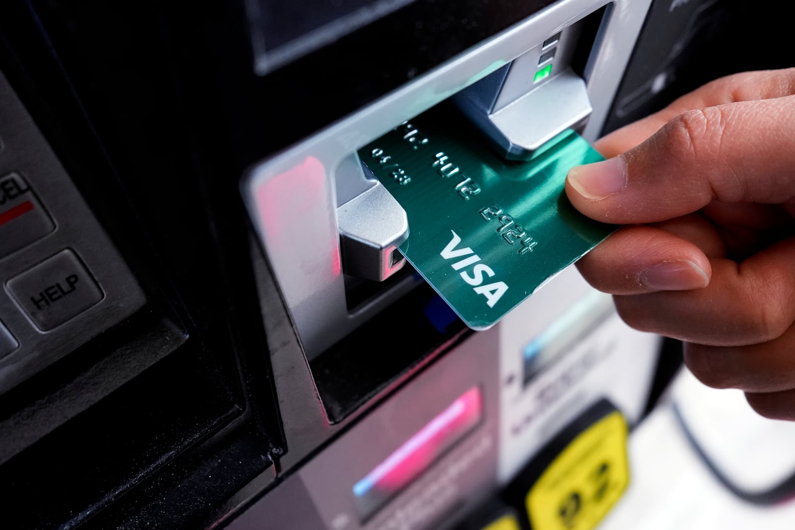 FILE - A customer uses a Visa credit card to pay for gasoline at a gas station. (AP Photo/Nam Y. Huh)