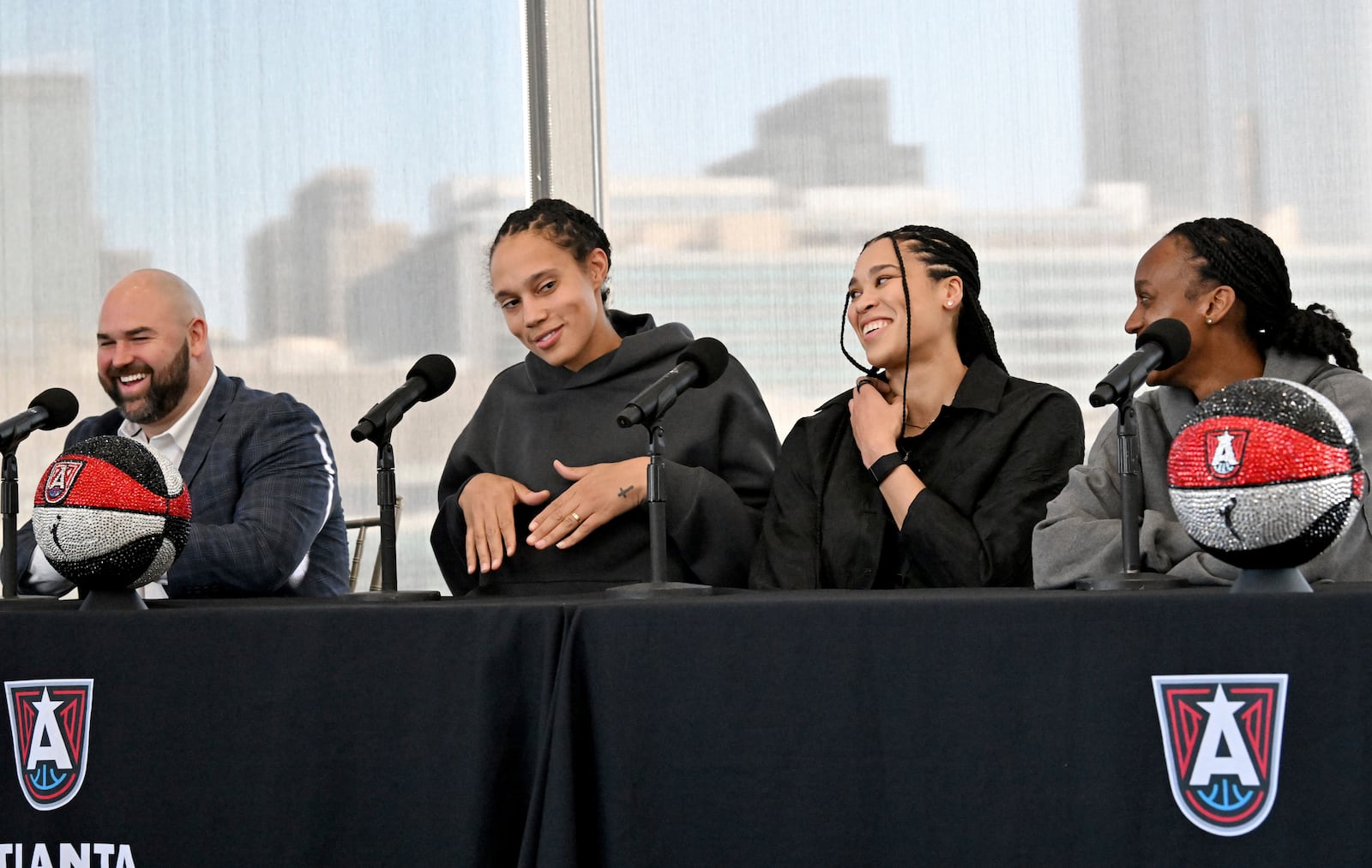 Atlanta Dream's Brittney Griner shows some dance moves, as new teammates Brionna Jones and Shatori Walker-Kimbrough, right, react during a WNBA basketball news conference, Tuesday, Feb. 4, 2025, in Atlanta. (Hyosub Shin/Atlanta Journal-Constitution via AP)