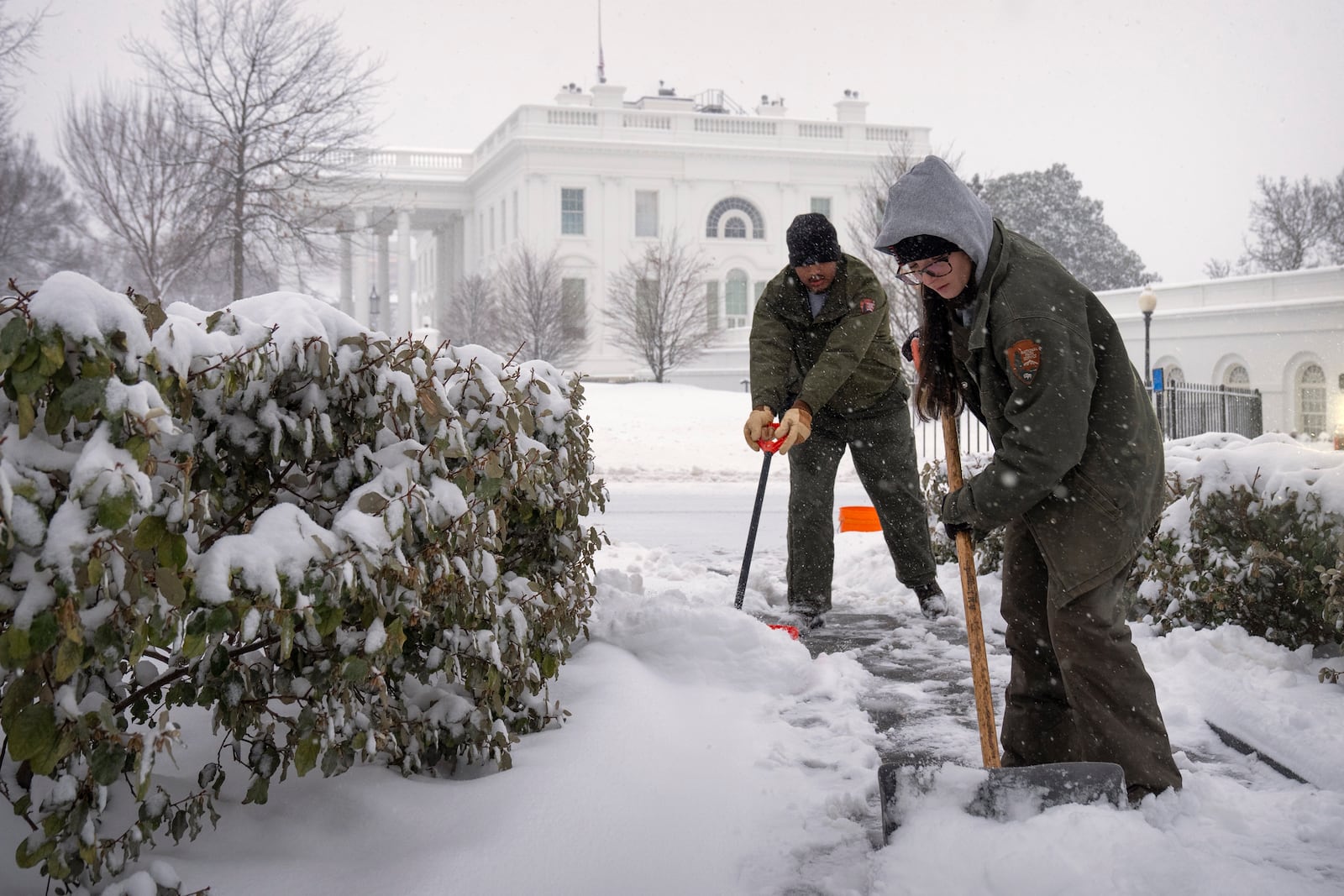 National Park Service workers shovel a pathway during a winter storm at the White House, Monday, Jan. 6, 2025, in Washington. (AP Photo/Mark Schiefelbein)