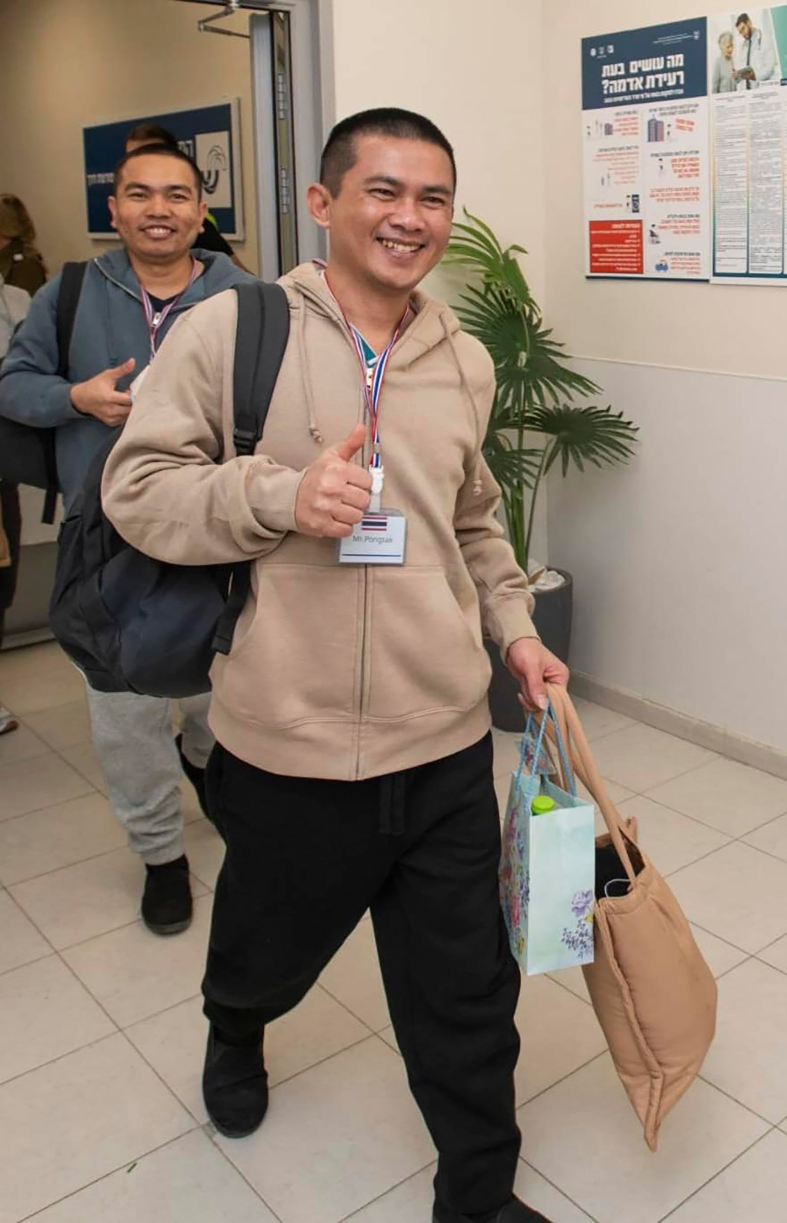 In this image released by Royal Thai Embassy in Tel Aviv Thai, Pongsak Thaenna, front, and Surasak Rumnao, two of five Thai hostages who were freed from Hamas, arrive in Israel, Thursday, Jan. 30, 2025. (Royal Thai Embassy in Tel Aviv via AP)