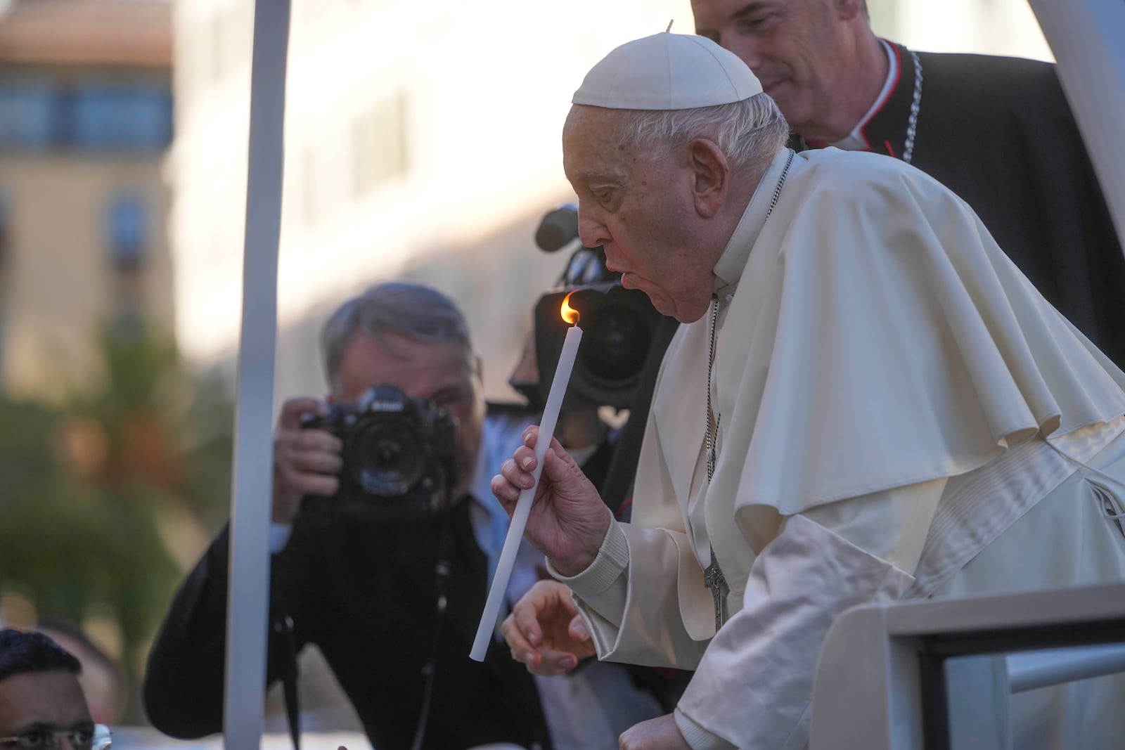 Pope Francis blows a candle as he prays in front of the statue of the Virgin Mary in Ajaccio on the occasion of his one-day visit in the French island of Corsica, Sunday, Dec. 15, 2024. (AP Photo/Alessandra Tarantino)