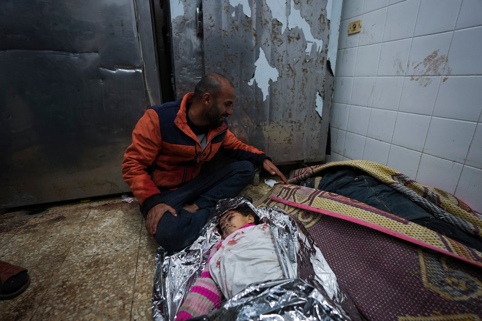 Adly Eid mourns over the body of his daughter, Dima, 5, who was killed in an Israeli airstrike, at the Al-Aqsa Hospital morgue in Deir Al-Balah, Gaza, Saturday, Jan. 11, 2025. (AP Photo/Abdel Kareem Hana)