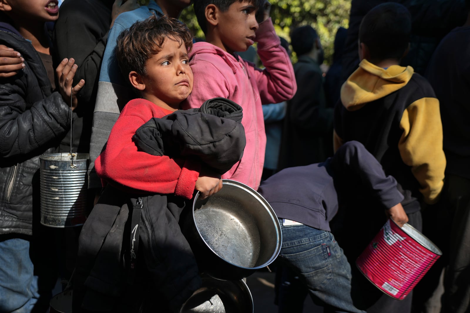 Palestinian children queue for food in Deir al-Balah, Gaza Strip, Friday, Dec. 13, 2024. (AP Photo/Abdel Kareem Hana)