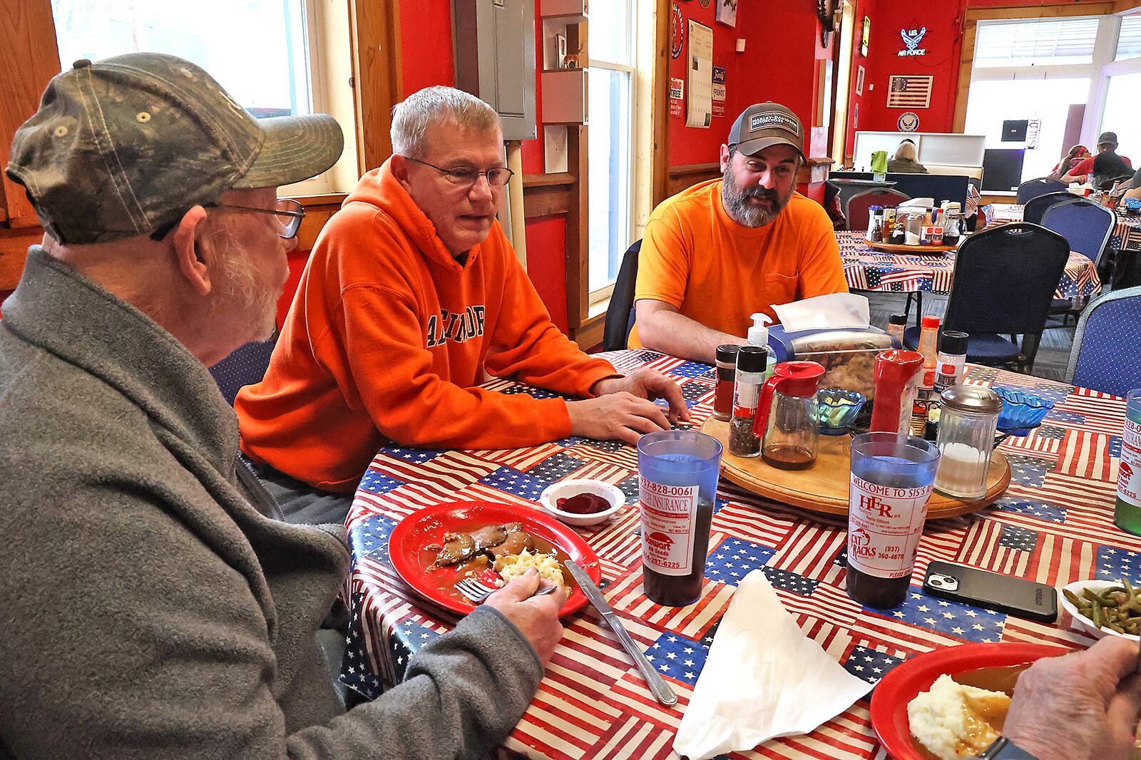 Matt Warner, center, the owner of Sis's Restaurant in Catawba, talks with some of his regular customers Thursday during lunch at the restaurant. Matt and his wife, Mandie, have decided to close the restaurant due to rising food costs. BILL LACKEY/STAFF