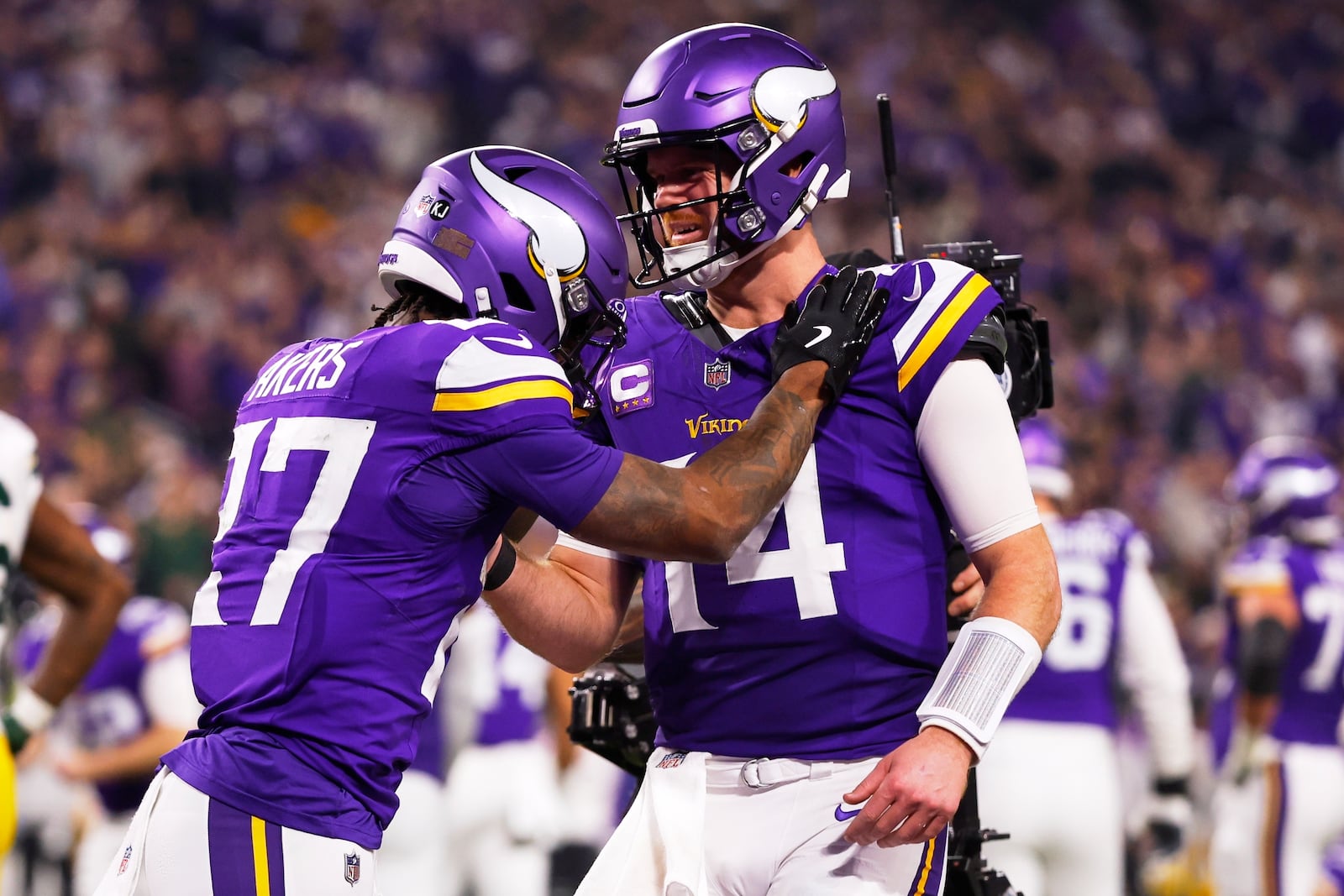 Minnesota Vikings' Sam Darnold congratulates Cam Akers on a touchdown catch during the second half of an NFL football game against the Green Bay Packers Sunday, Dec. 29, 2024, in Minneapolis. (AP Photo/Bruce Kluckhohn)