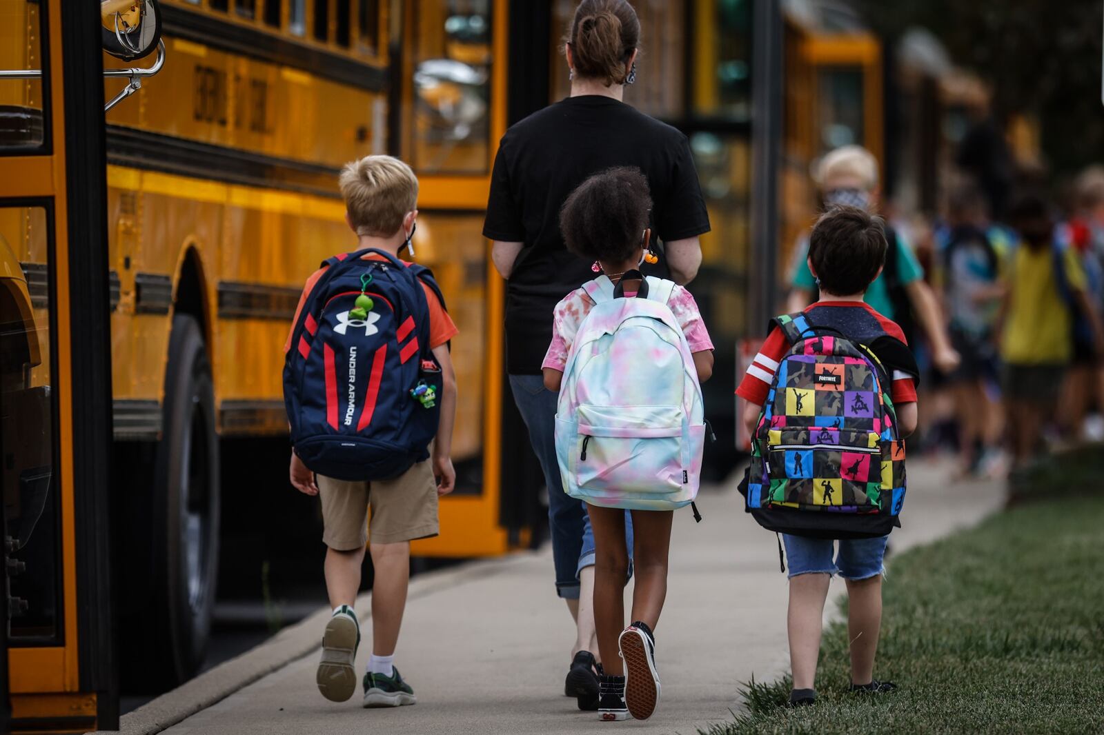 Children at Cline Elementary School in Centerville load into buses after the first day of school Wednesday August 18, 2021. All of the kids were wearing masks. JIM NOELKER/STAFF