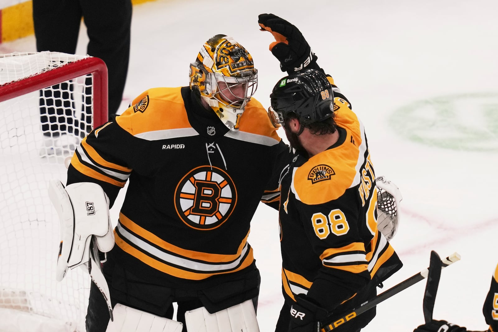 Boston Bruins goaltender Jeremy Swayman is congratulated by David Pastrnak (88) after defeating the Florida Panthers following an NHL hockey game, Tuesday, March 11, 2025, in Boston. (AP Photo/Charles Krupa)