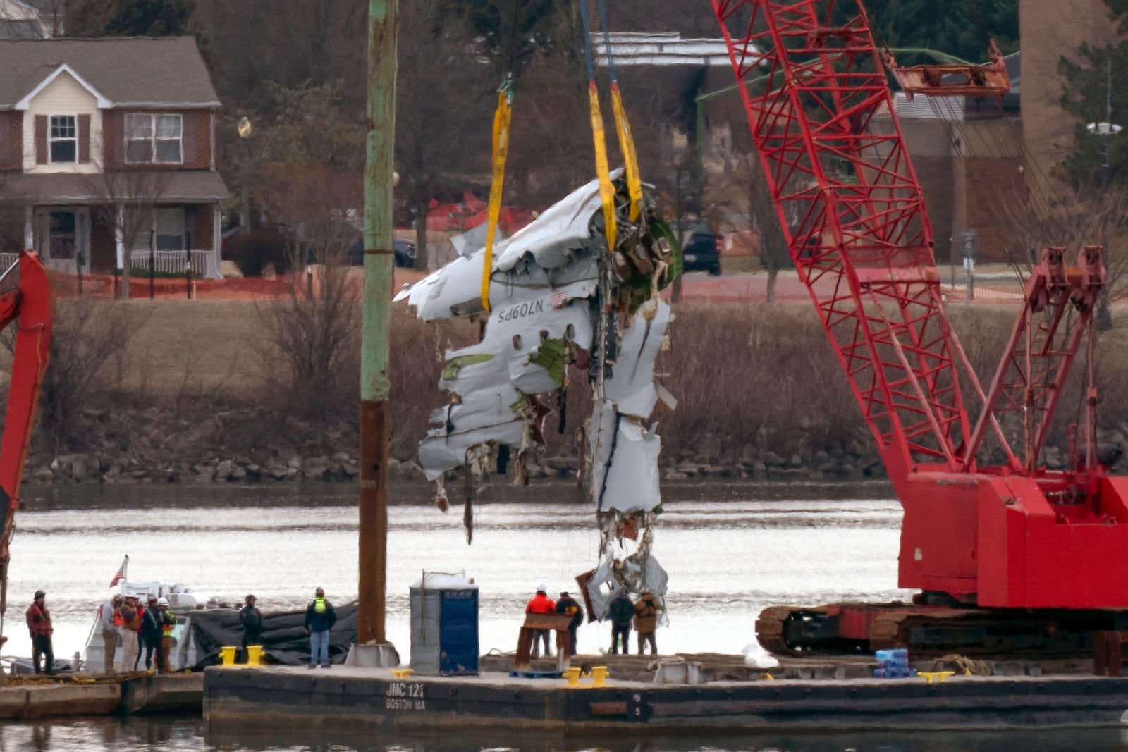 Crews pull up a part of a plane from the Potomac River near Ronald Reagan Washington National Airport, Monday, Feb. 3, 2025, in Arlington, Va. (AP Photo/Jose Luis Magana)