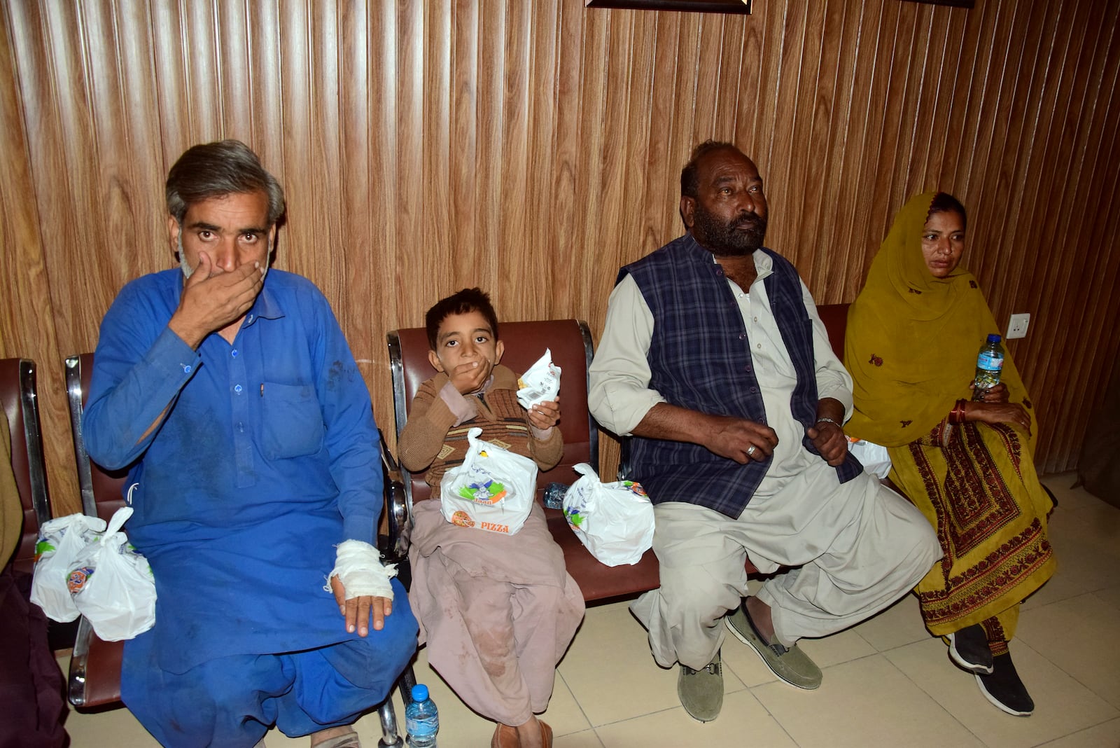 Passengers rescued by security forces from a passenger train attacked by insurgents eat food upon their arrival at a railway station in Quetta, Pakistan, Wednesday, March 12, 2025. (AP Photo/Arshad Butt)