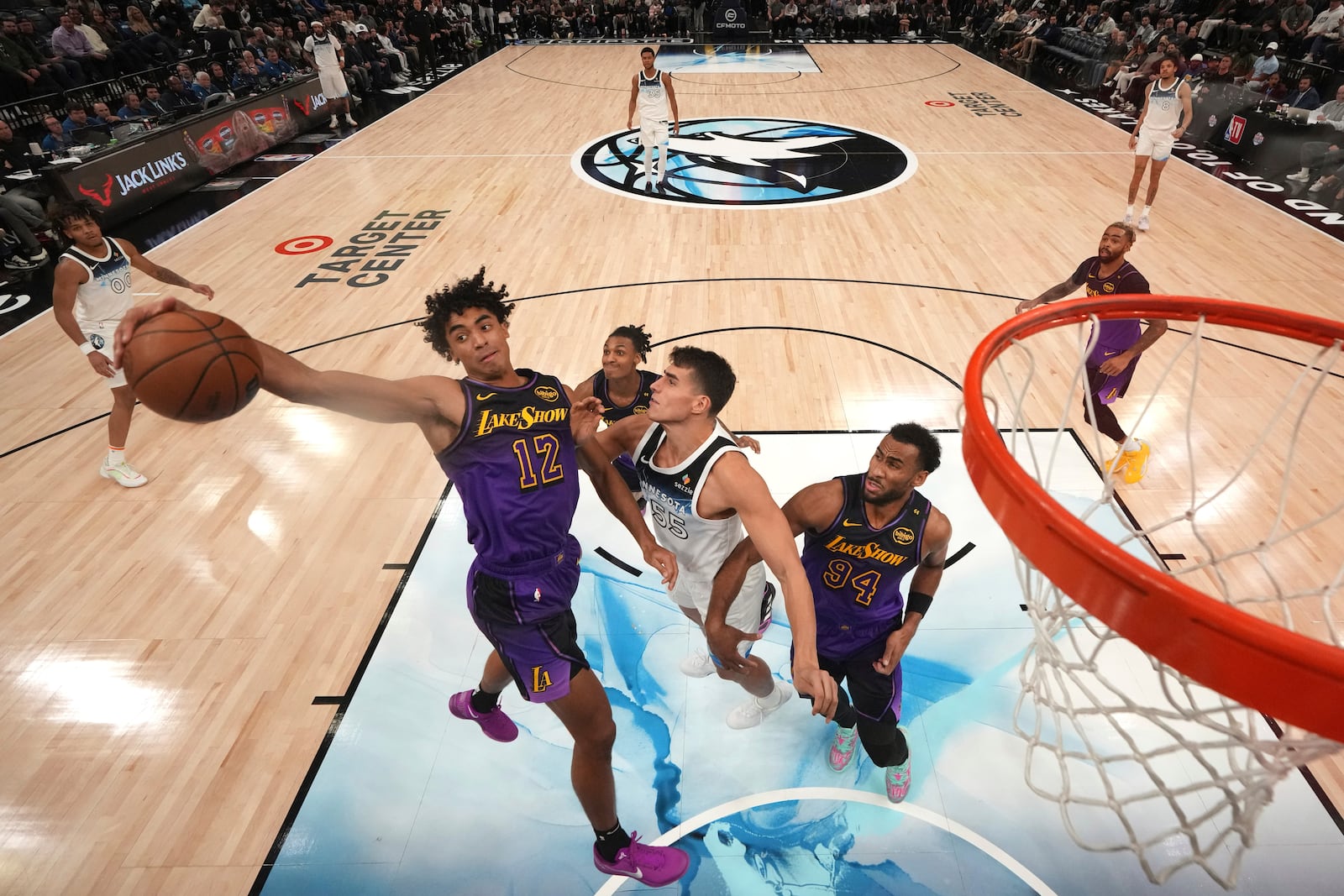 Los Angeles Lakers guard Max Christie (12) reaches for a rebound against Minnesota Timberwolves center Luka Garza (55) during the second half of an NBA basketball game, Monday, Dec. 2, 2024, in Minneapolis. (AP Photo/Abbie Parr)