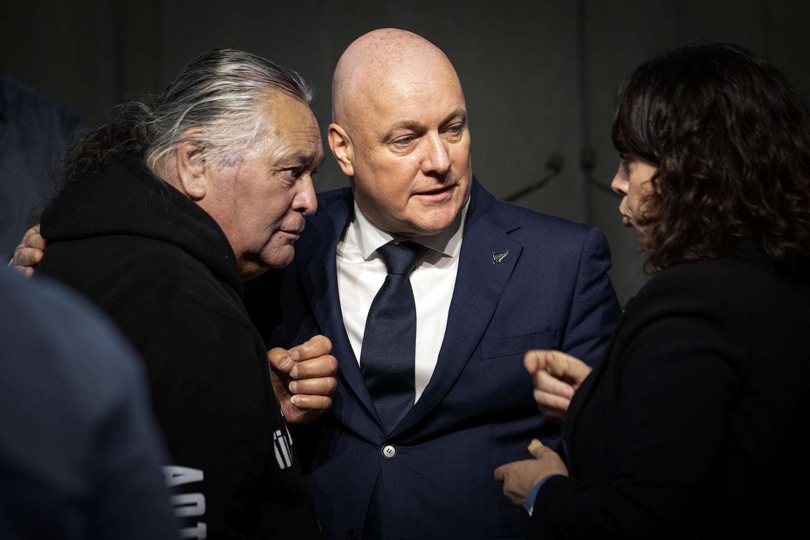 New Zealand's Prime Minister Christopher Luxon, center, talks with survivor Whiti Ronaki, left, and Laura Cherrington following his "formal and unreserved" apology in Parliament for the widespread abuse, torture and neglect of hundreds of thousands of children and vulnerable adults in care, in Wellington, New Zealand Tuesday, Nov. 12, 2024. (Monique Ford/Stuff via AP)