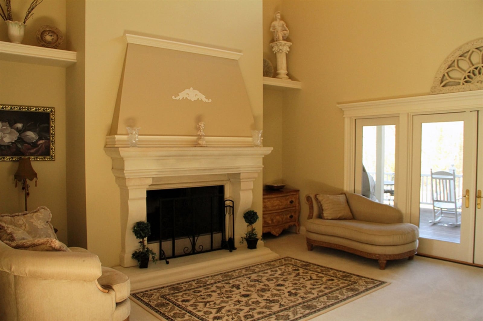 Curved posts and extended millwork above a wide mantel add a European flair to the living room’s fireplace.