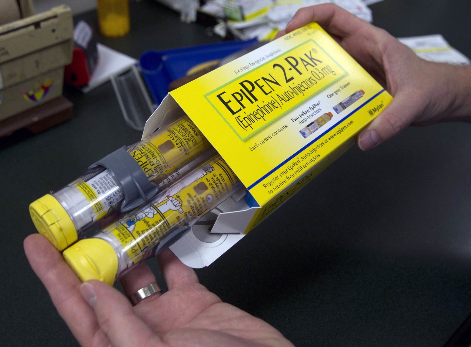 In this July 8, 2016, file photo, a pharmacist holds a two-pack of the EpiPen epinephrine auto-injector. Mylan last year began selling a generic version of the emergency allergy treatment after the high price for the branded option drew public scorn and congressional inquiries. (AP Photo/Rich Pedroncelli, File)