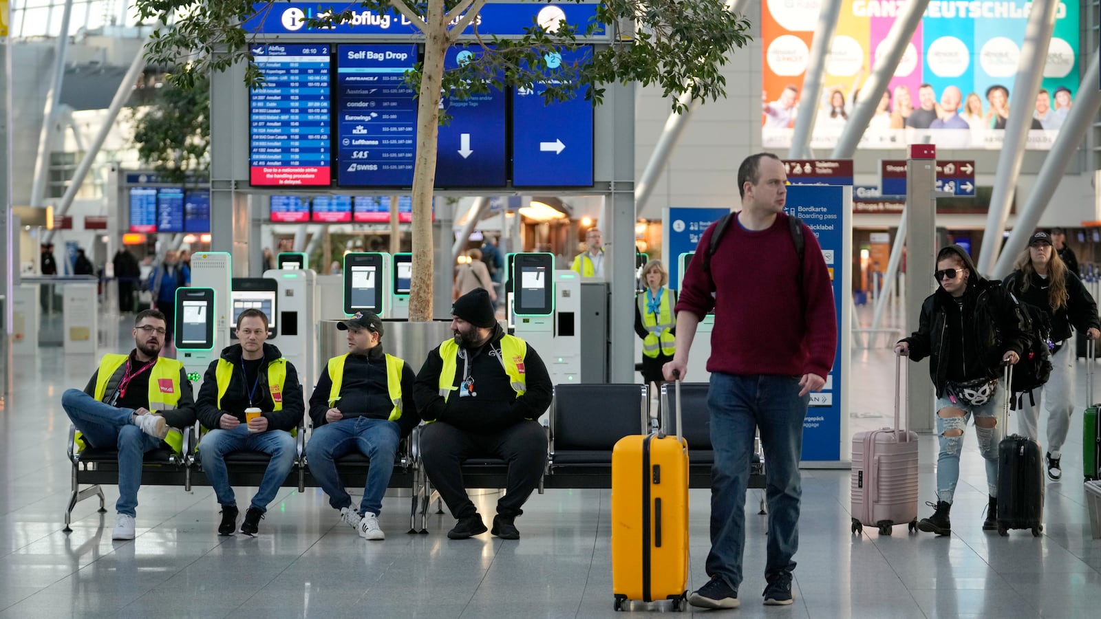 Airport workers protest during a strike of the union ver.di at the airport in Duesseldorf, Germany on Monday, March 10, 2025, when all major airports in Germany went on a warning strike. (AP Photo/Martin Meissner)