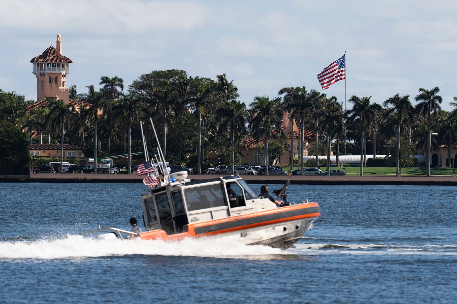 The U.S. flag is shown at the Mar-a-Lago compound in Palm Beach, Fla., while a U.S. Coast Guard boat patrols around the vicinity, Monday, Jan. 13, 2025. U.S. flags at President-elect Donald Trump's private Mar-a-Lago club are back to flying at full height. Flags are supposed to fly at half-staff through the end of January out of respect for former President Jimmy Carter, who died Dec. 29. (AP Photo/Manuel Balce Ceneta)