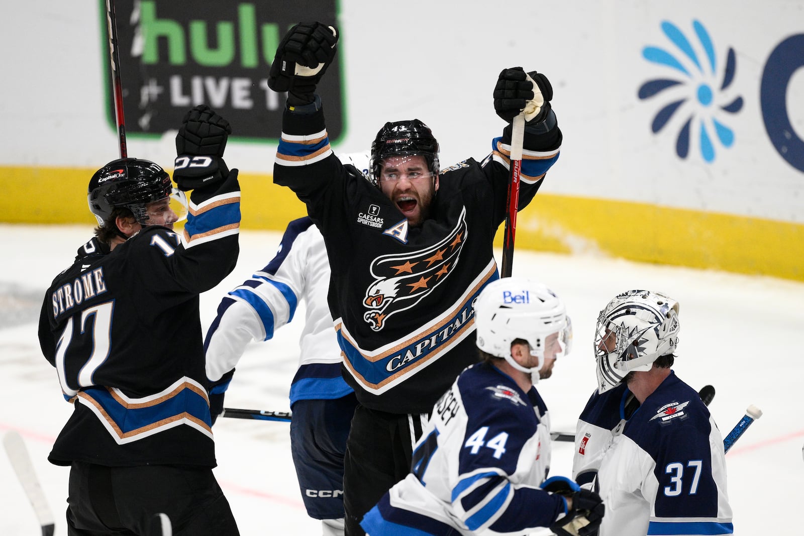 Washington Capitals right wing Tom Wilson (43) celebrates his goal with center Dylan Strome (17) against Winnipeg Jets goaltender Connor Hellebuyck (37) during the third period of an NHL hockey game, Saturday, Feb. 1, 2025, in Washington. (AP Photo/Nick Wass)