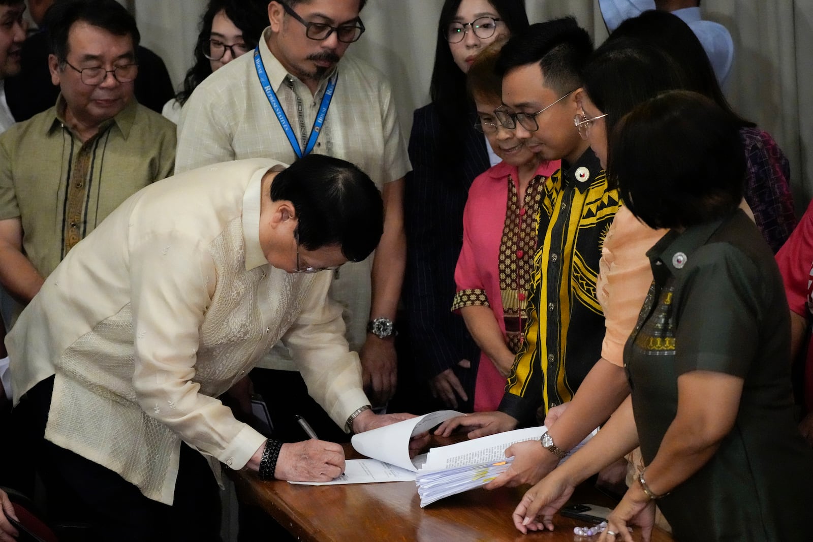 House Secretary General, Reginald Velasco, left, signs a document as a second impeachment complaint is filed against Philippine Vice President Sara Duterte by a group led by left-wing activists on Wednesday Dec. 4, 2024 at the House of Representatives in Quezon City, Philippines. (AP Photo/Aaron Favila)