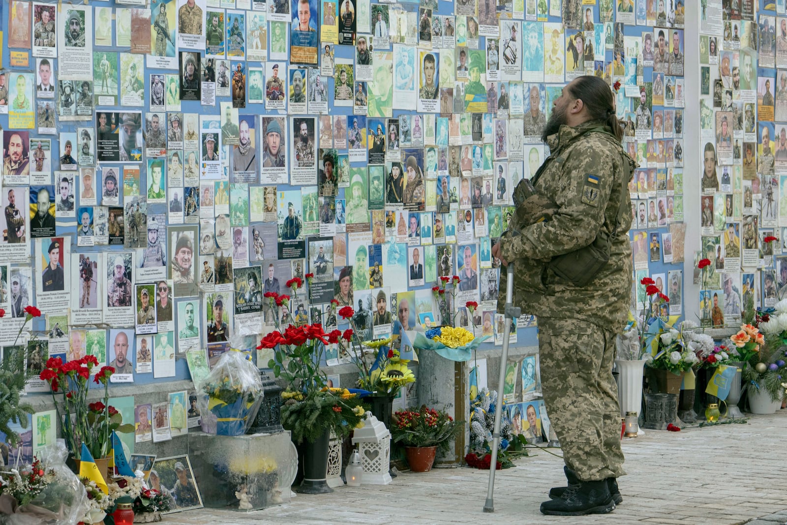 A serviceman mourns at the Memorial Wall of Fallen Defenders of Ukraine in Russian-Ukrainian War in Kyiv, Ukraine, Monday, Feb. 24, 2025. (AP Photo/Andrew Kravchenko)