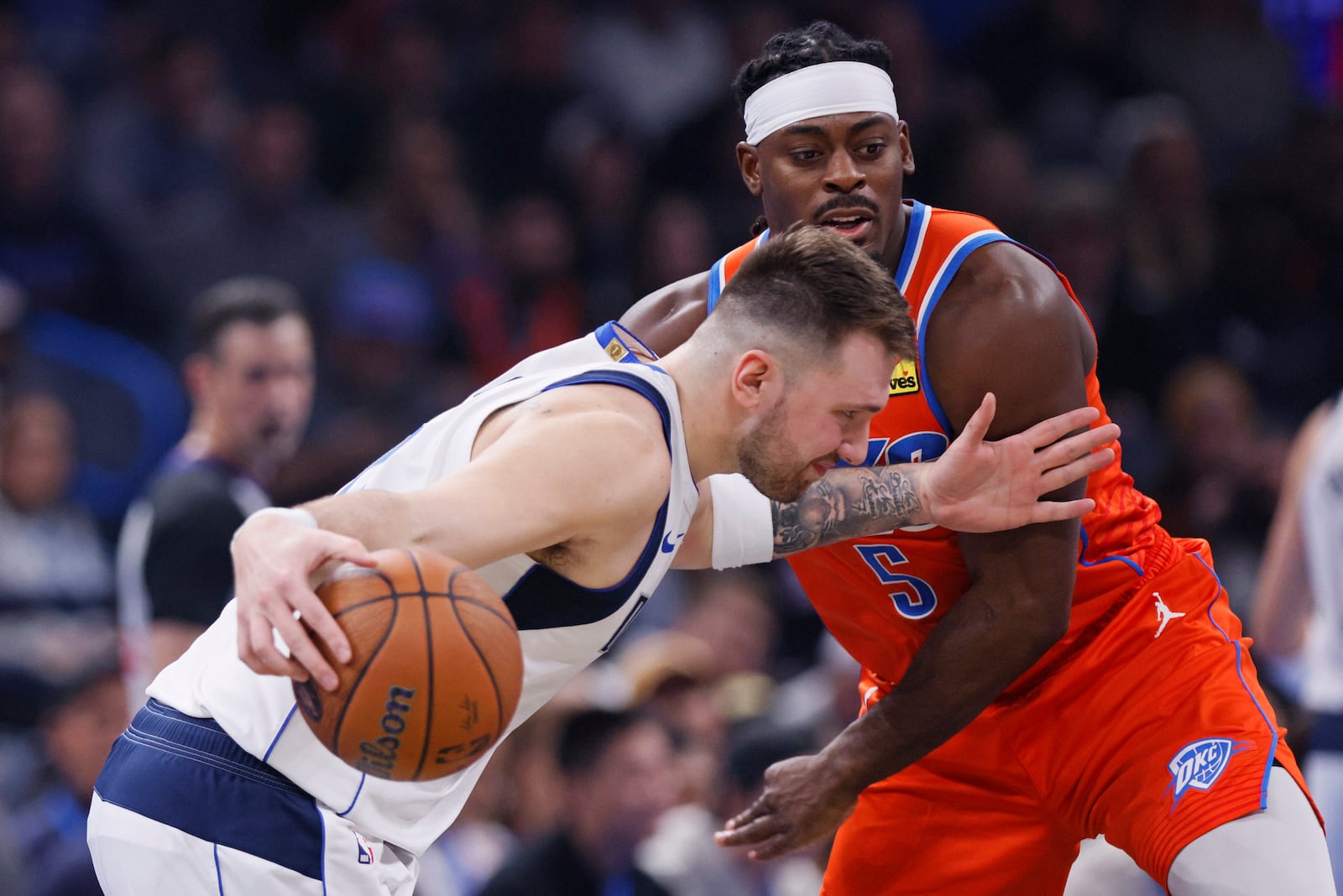 Dallas Mavericks guard Luka Doncic, left, drives against Oklahoma City Thunder guard Luguentz Dort (5) during the first half of an Emirates NBA Cup basketball game, Tuesday, Dec. 3, 2024, in Oklahoma City. (AP Photo/Nate Billings)