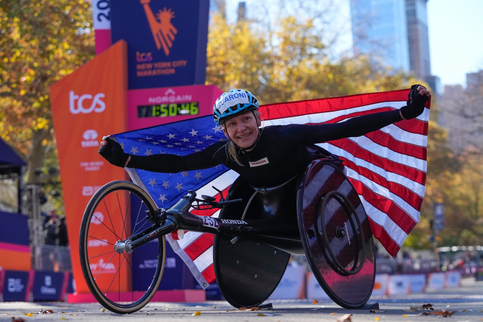 Susannah Scaroni crosses poses for photographs after winning the women's wheelchair division of the New York City Marathon, Sunday, Nov. 3, 2024, in New York. (AP Photo/Frank Franklin II)