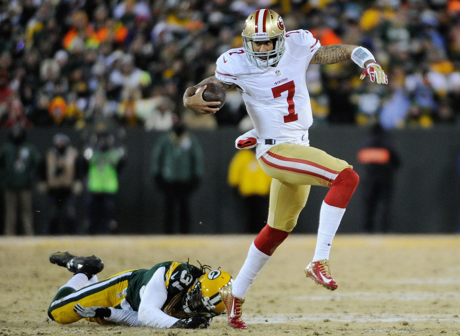 San Francisco 49ers quarterback Colin Kaepernick runs past Green Bay Packers cornerback Davon House during their 2013 NFC wild card playoff football game at Lambeau Field.