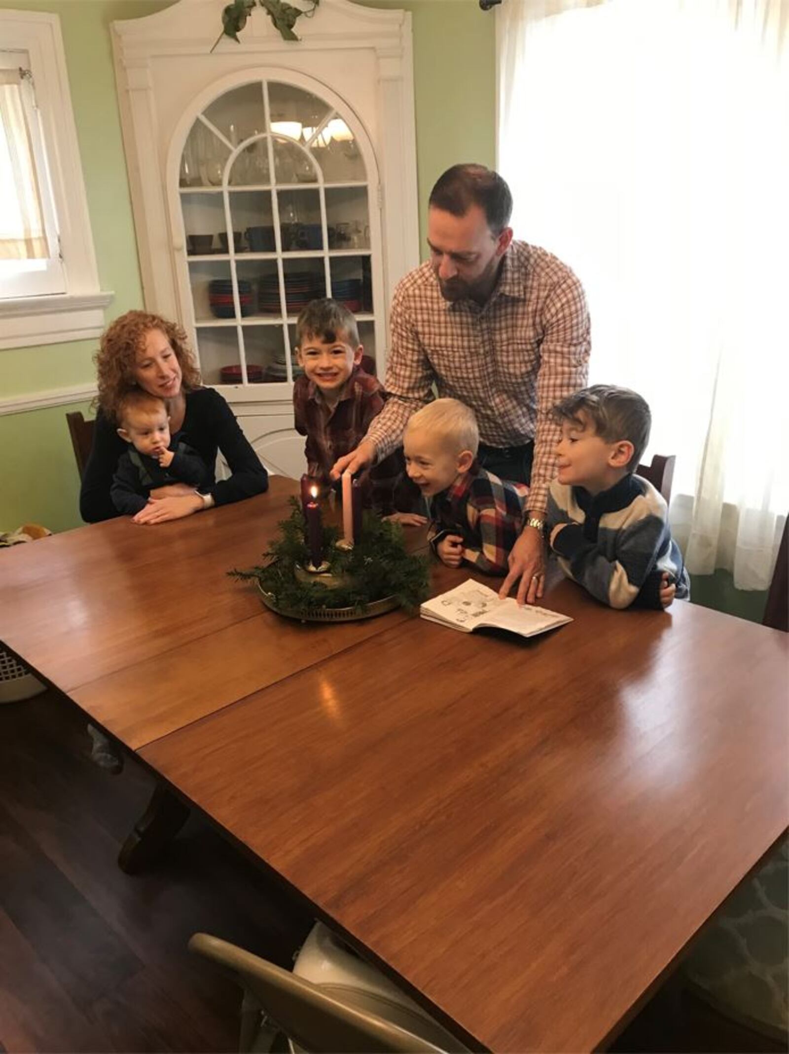 Lighting the candle on their Advent wreath are members of the Nieport family. Pictured left to right are Tina, holding Max, Isaac, Chris (lighting the candle) Avery, and Thane. SUBMiTTED