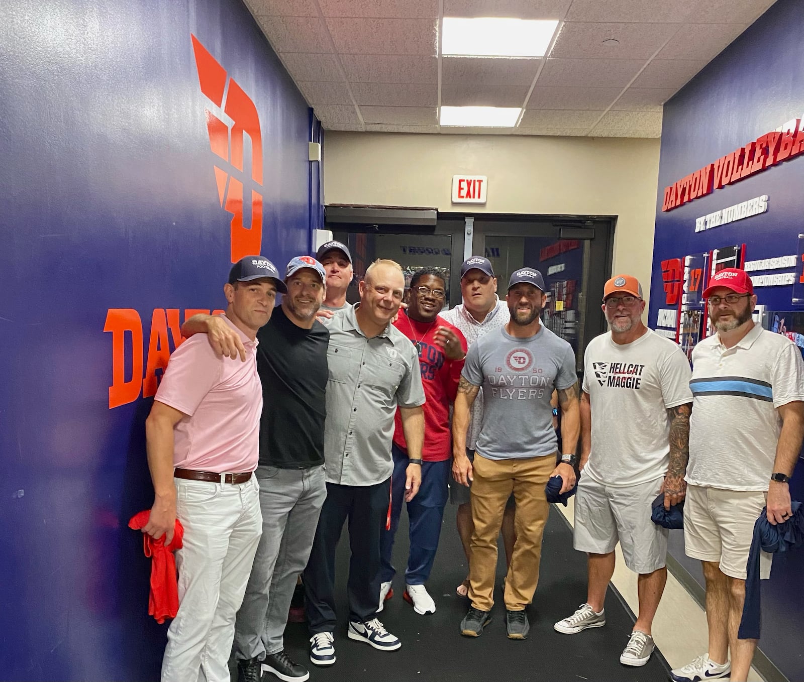 Dayton coach Trevor Andrews poses for a photo in the locker room with former UD teammates on Friday, Sept. 8, 2023, at UD Arena. Photo courtesy of UD