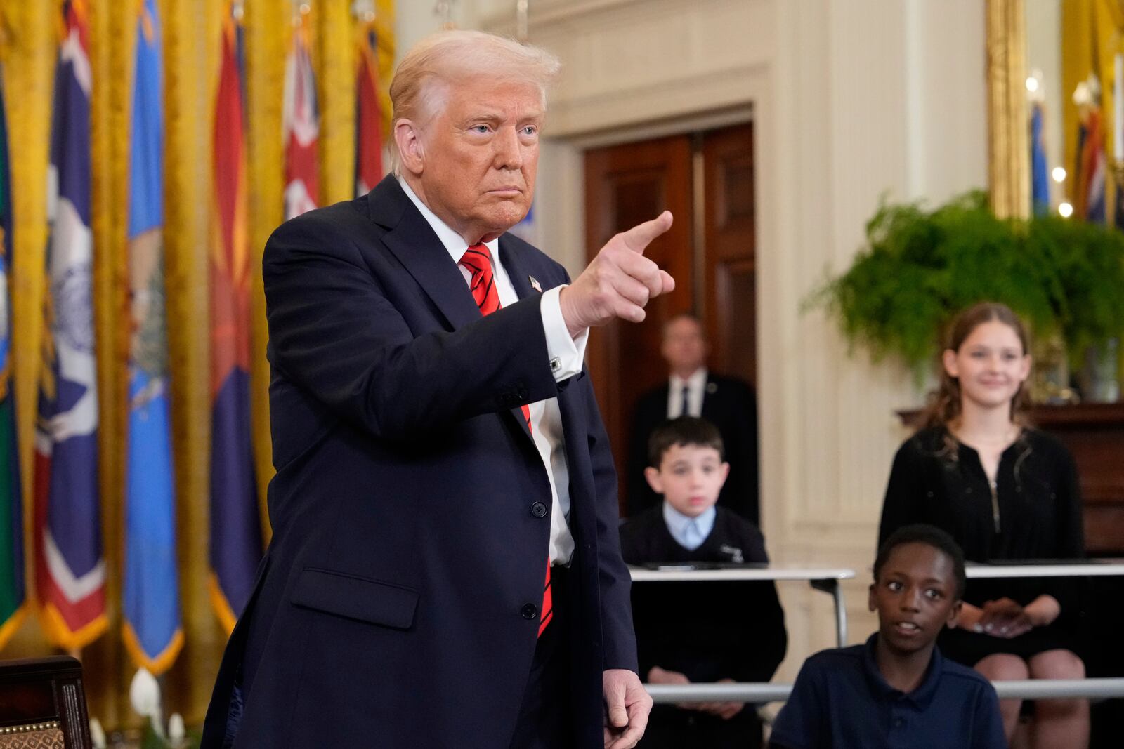 President Donald Trump gestures after signing executive order in the East Room of the White House in Washington, Thursday, March 20, 2025. (AP Photo/Ben Curtis)