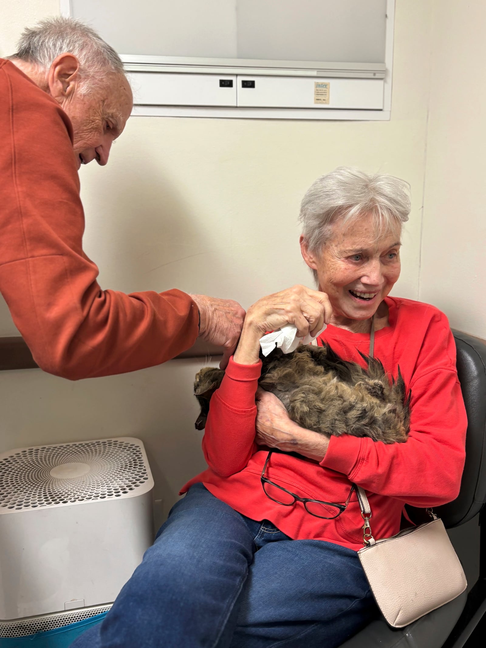 In this image provided by Carolyn Kiefer her mother, Katherine Kiefer, 82, is reunited with her cat Aggie at VCA Chatoak Animal Hospital after the Palisades Fire destroyed her home and the cat was missing, Saturday, March 8, 2025, in Los Angeles. (Carolyn Kiefer via AP)