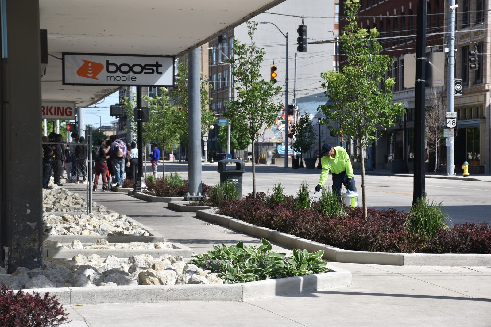 A downtown Dayton ambassador picks up trash in flower beds along South Jefferson Street near the Greater Dayton RTA bus hub downtown. The city paid to install new landscaping that is designed to try to prevent loitering and other problems. CORNELIUS FROLIK / STAFF