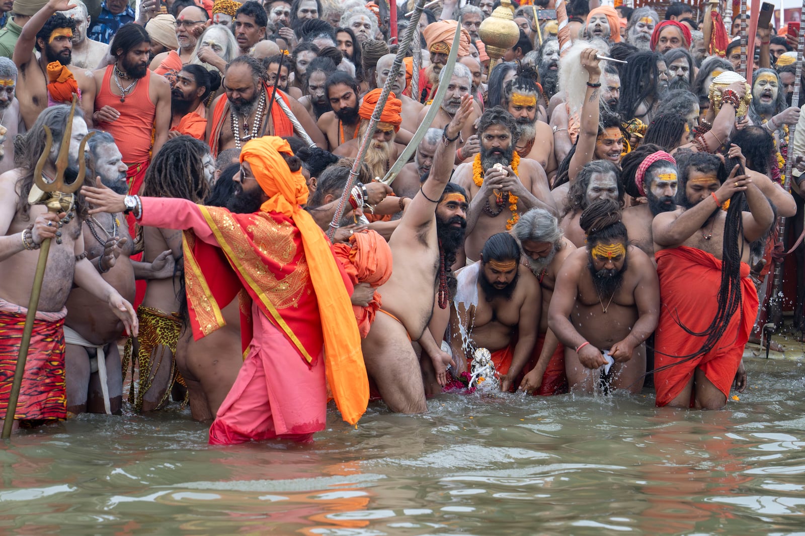 Hindu ascetics and holy men immerse an idol before bathing at the confluence of the Ganges, the Yamuna and the mythical Saraswati rivers on the second day of the 45-day-long Maha Kumbh festival in Prayagraj, India, Tuesday, Jan. 14, 2025. (AP Photo/Ashwini Bhatia)