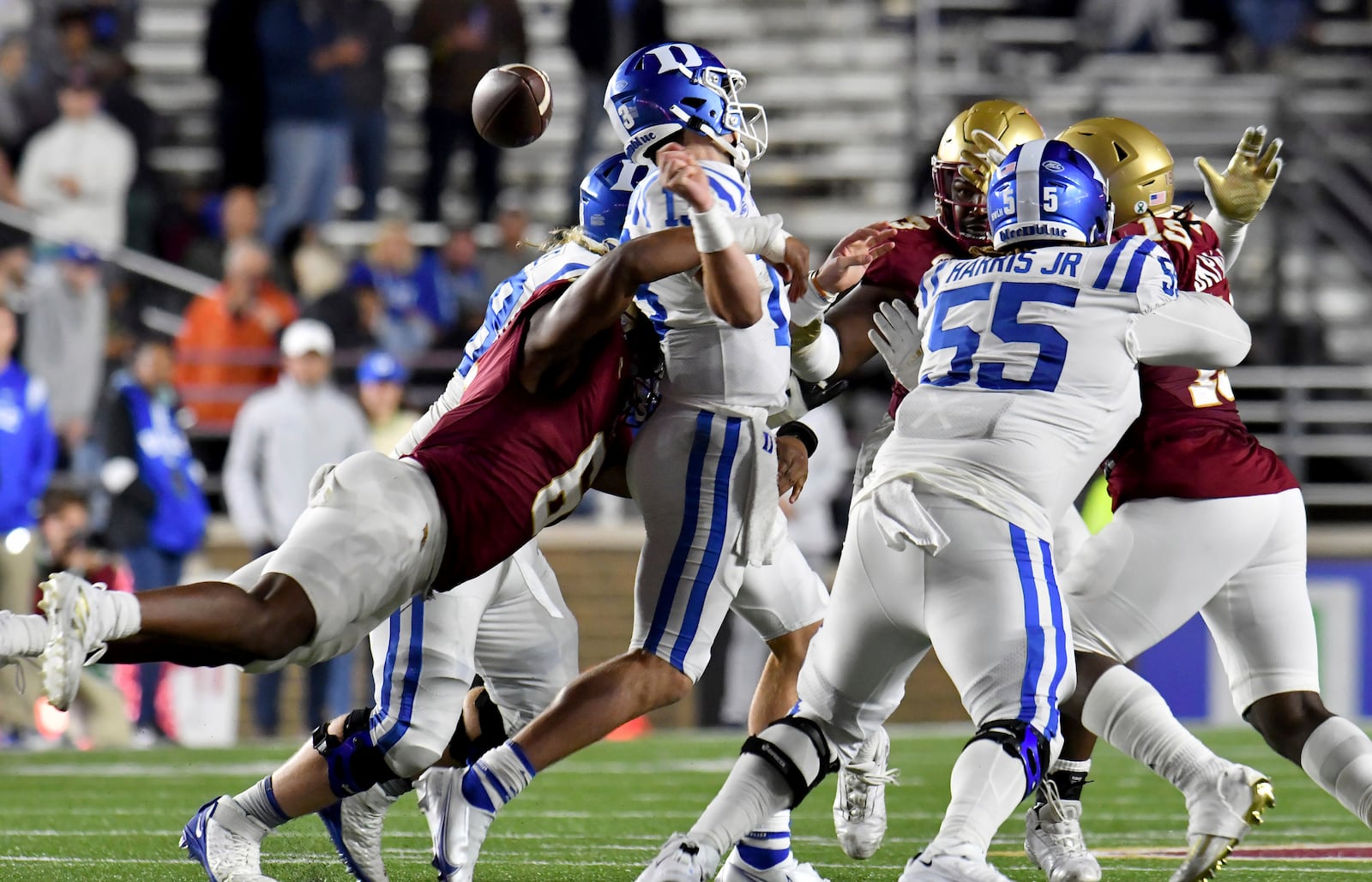 FILE - Duke quarterback Riley Leonard, center, is hit by Boston College defenseman Donovan Ezeiruaku, left, causing the ball to come loose, during the second half of an NCAA college football game, Nov. 4, 2022, in Boston. (AP Photo/Mark Stockwell, File)