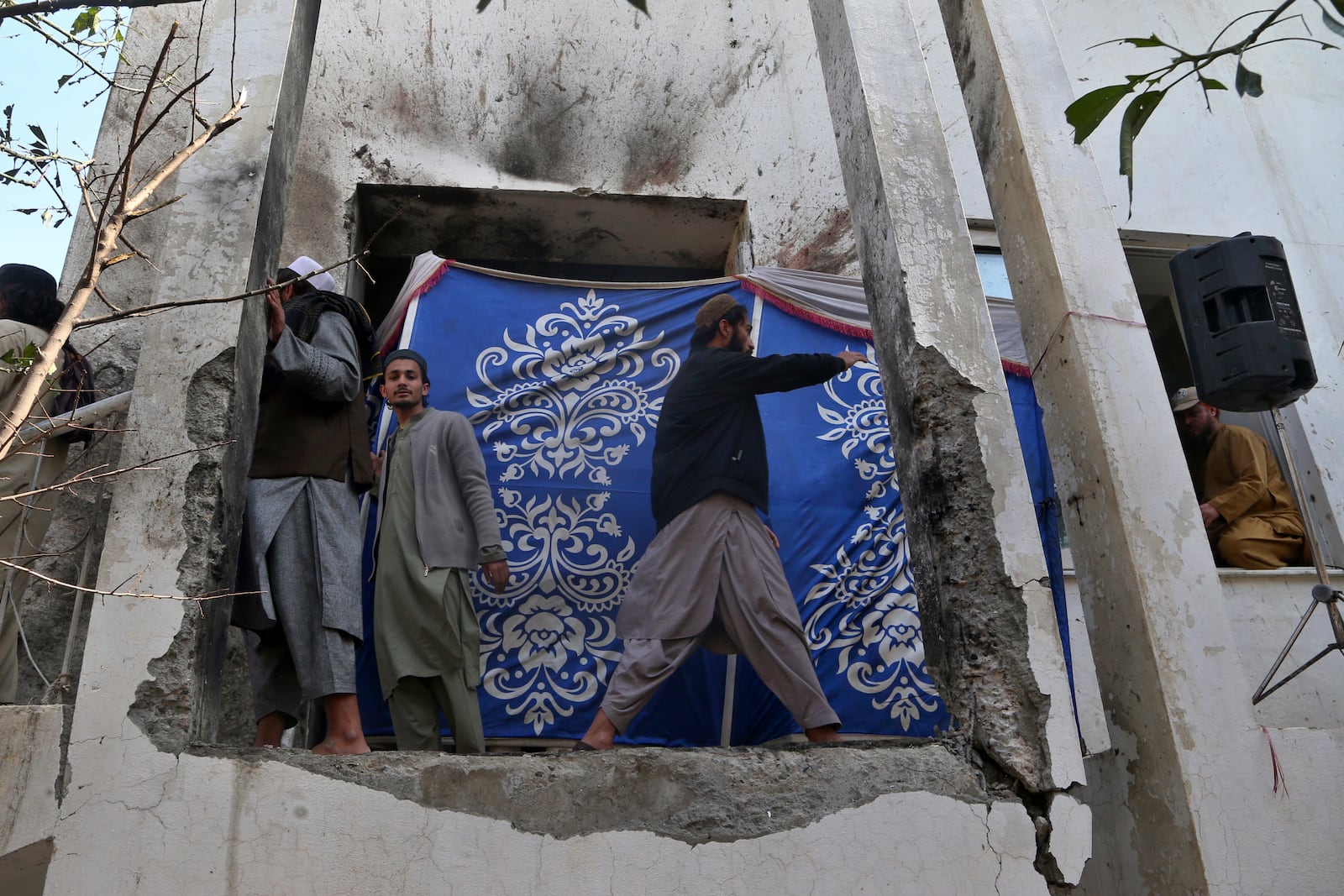 Mourners look at the site of Friday's suicide bombing following the funeral prayer of a senior Muslim cleric, Hamidul Haq, at a pro-Taliban seminary in Akora Khattak, Pakistan, Saturday, March 1, 2025. (AP Photo/Muhammad Sajjad)