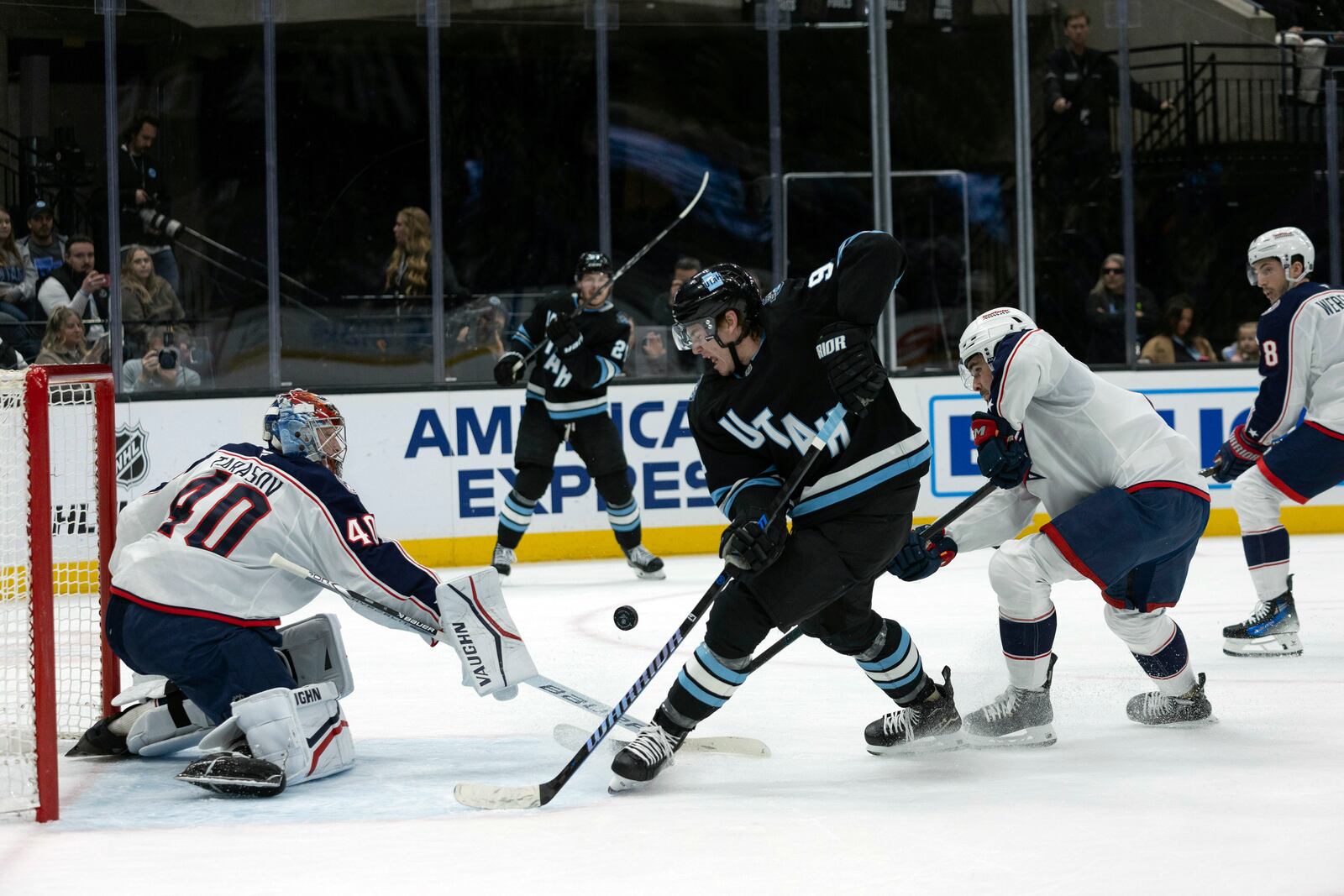 Utah Hockey Club center Clayton Keller (9) goes after the puck against Columbus Blue Jackets goaltender Daniil Tarasov (40) and defenseman Dante Fabbro, second from right, during the first period of an NHL hockey game Friday, Jan. 31, 2025, in Salt Lake City. (AP Photo/Melissa Majchrzak)