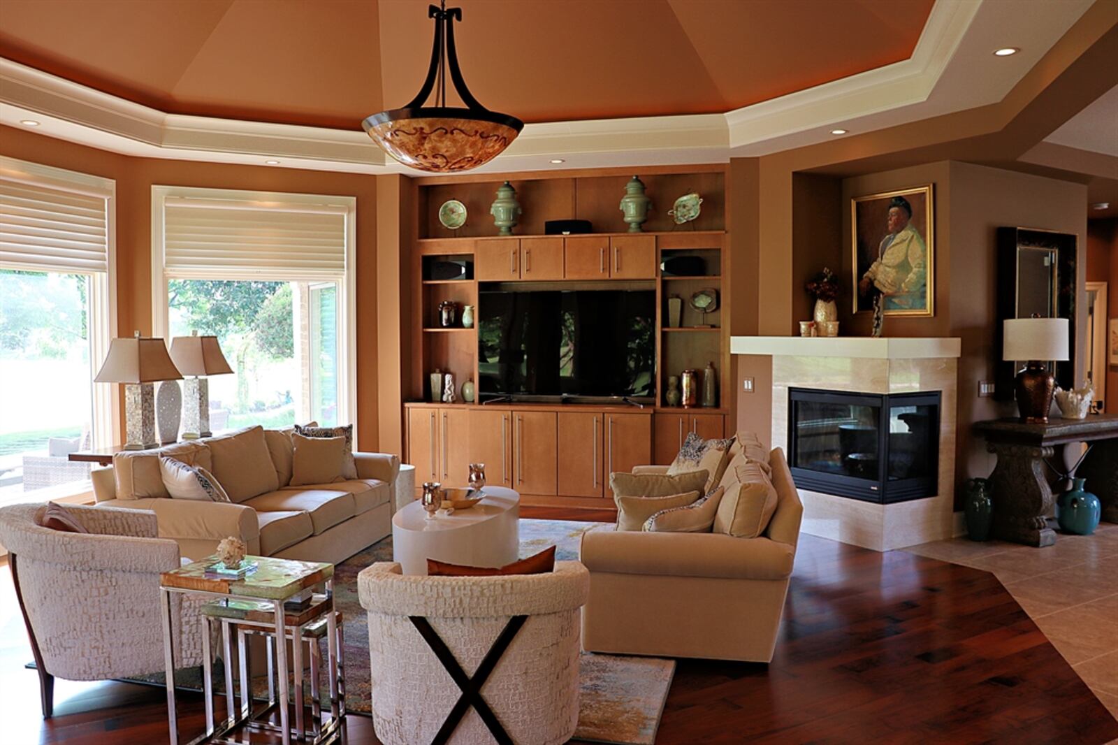 The dome ceiling above the living room adds to the openness as does a picture window. Another wall has built-in cabinetry that leads to a dual-sided corner gas fireplace.