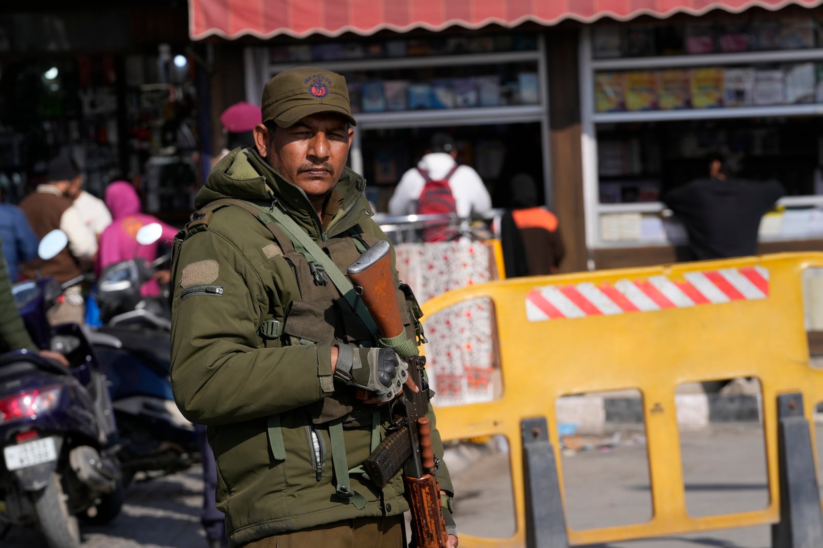 An Indian policeman guards outside his post near a book shop at a market in Srinagar, Indian controlled Kashmir, Monday, Feb. 17, 2025. (AP Photo/Mukhtar Khan)