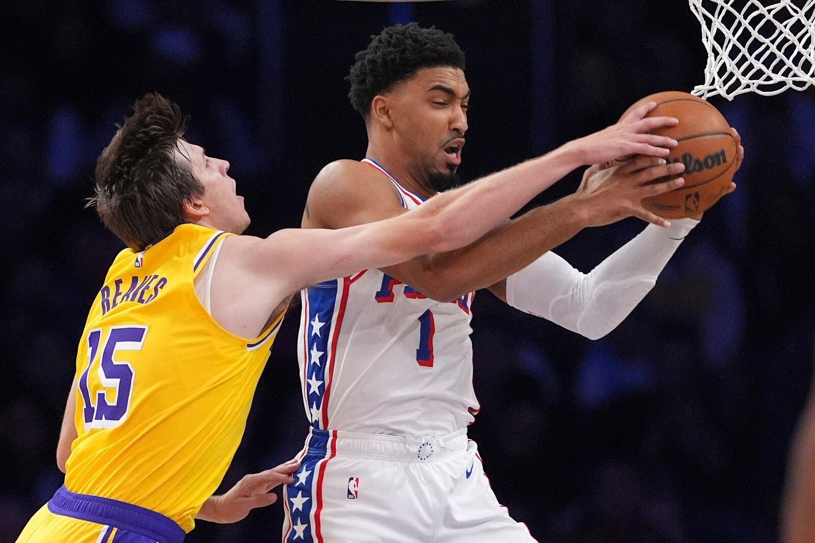 Los Angeles Lakers guard Austin Reaves, left, and Philadelphia 76ers forward KJ Martin reach for a rebound during the first half of an NBA basketball game, Friday, Nov. 8, 2024, in Los Angeles. (AP Photo/Mark J. Terrill)