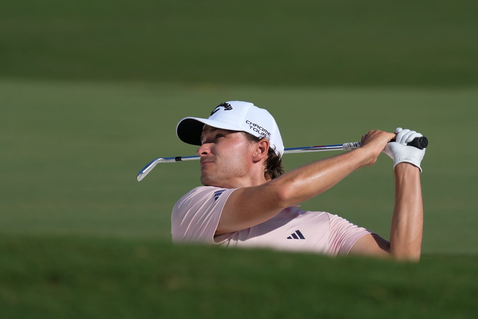 Rasmus Højgaard of Denmark hits a shot from a bunker on the 18th hole during the second round of World Tour Golf Championship in Dubai, United Arab Emirates, Friday, Nov. 15, 2024. (AP Photo/Altaf Qadri)