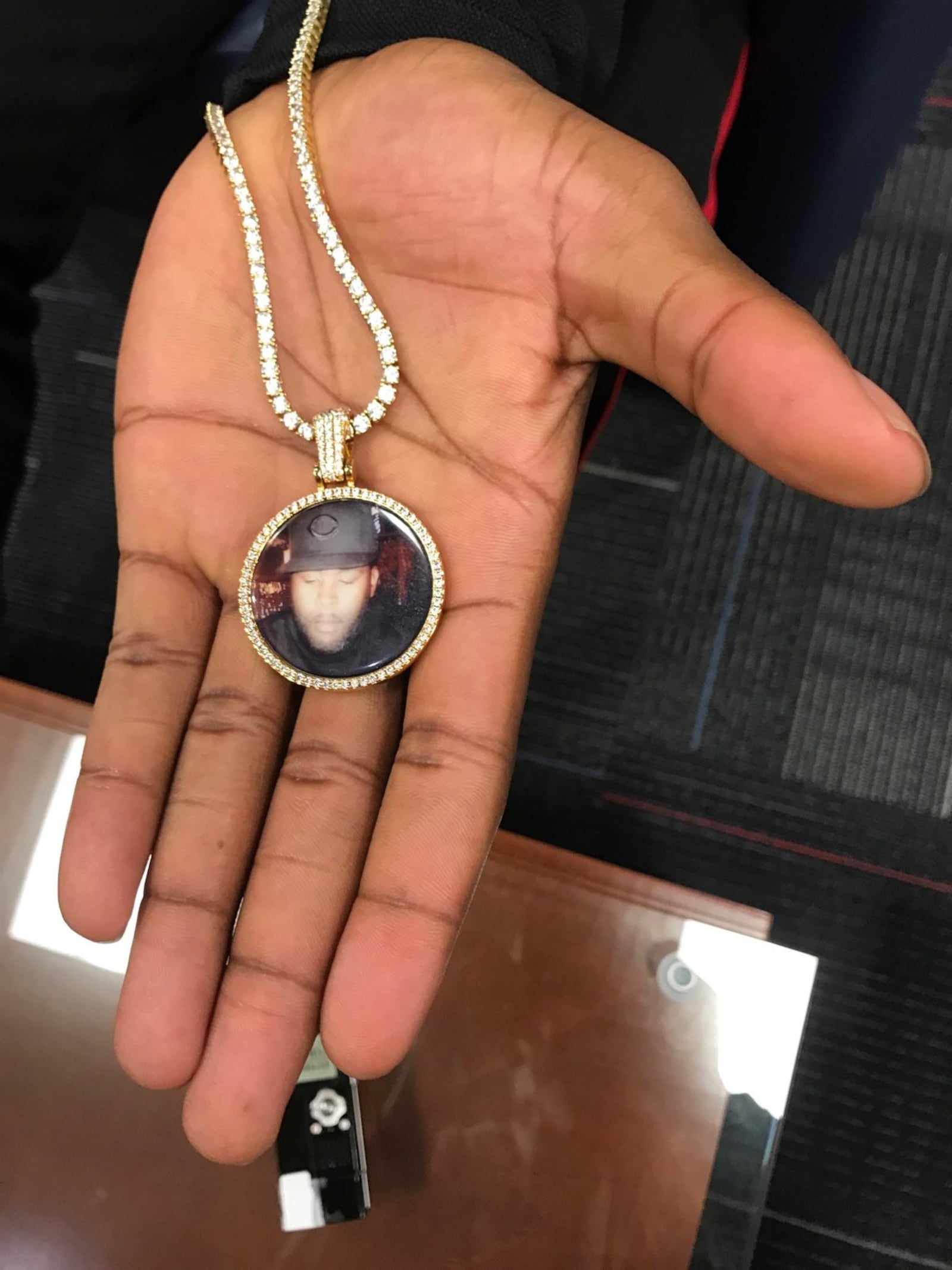 Dayton’s Trey Landers with medallion he wears around his neck. It holds a photo of his late father. Tom Archdeacon/STAFF