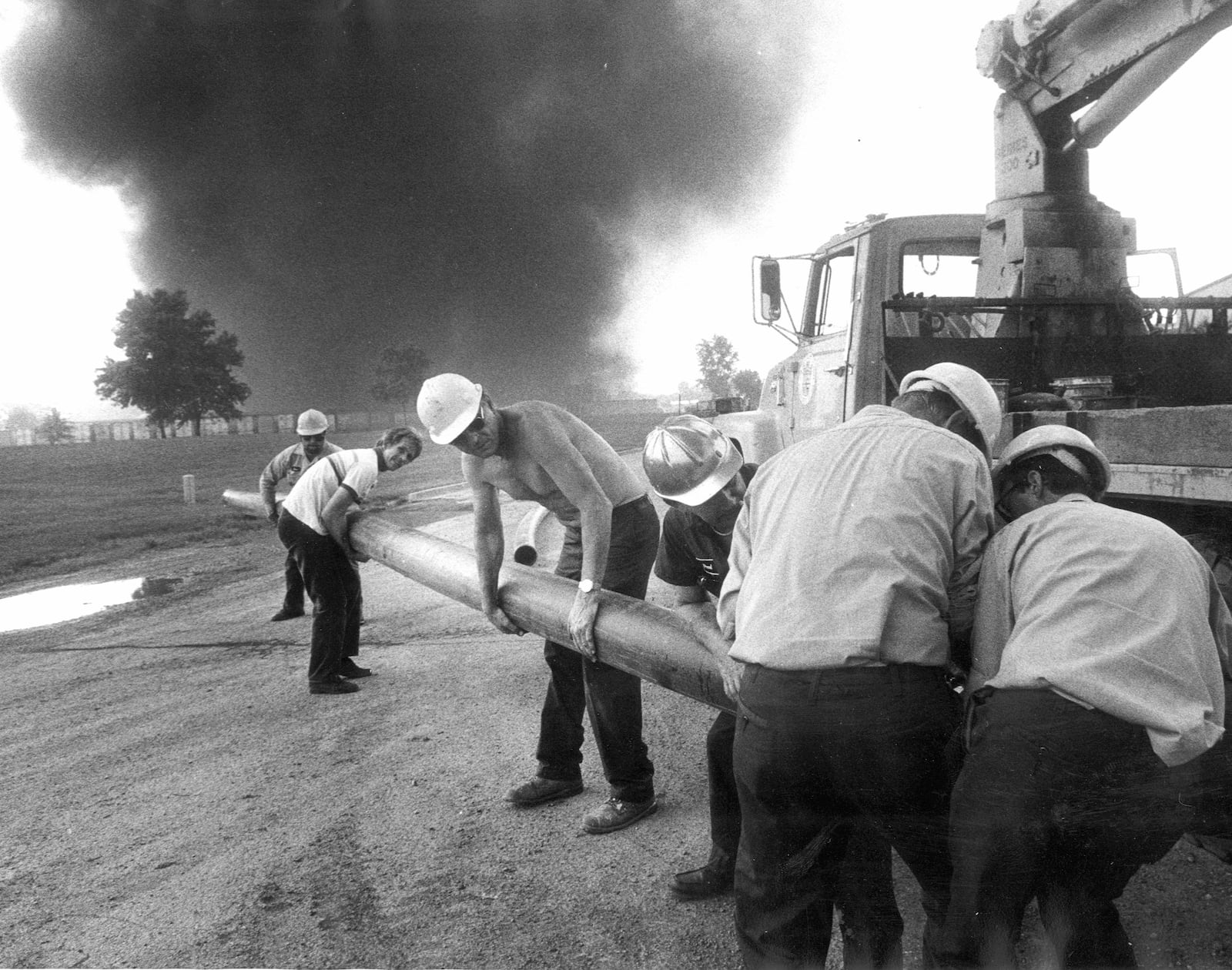 Dayton Water Supply workers put down rubber hose which will supply water to drain sewers which were on fire during the Sherwin-Williams warehouse fire in 1987. DAYTON DAILY NEWS ARCHIVE