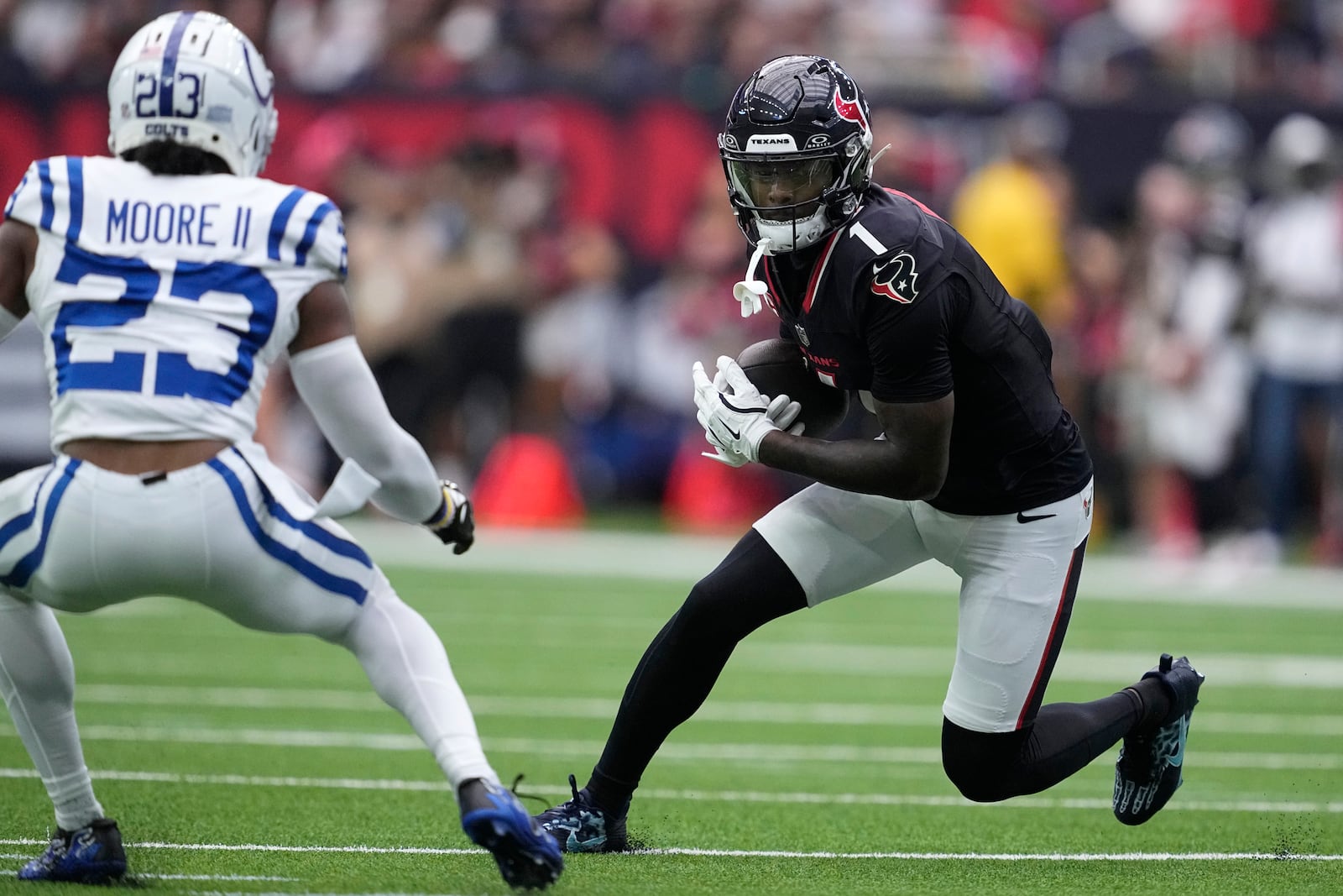 Houston Texans wide receiver Stefon Diggs (1) runs from Indianapolis Colts cornerback Kenny Moore II (23) after catching a pass during the first half of an NFL football game, Sunday, Oct. 27, 2024, in Houston. (AP Photo/Tony Gutierrez)