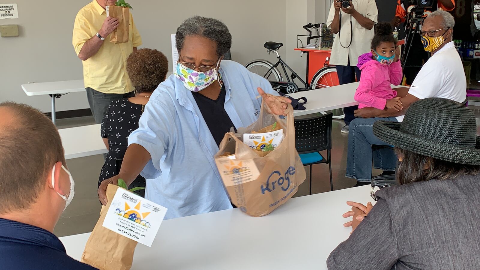 Omope Carter-Daboiku, farm manager for the Greater Edgemont Community Coalition, passes out pesto from their solar garden at an event announcing micro-grants for Dayton groups fighting hunger.