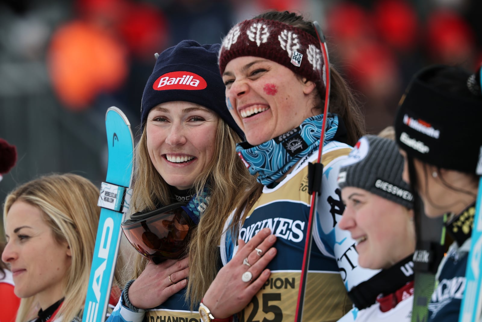 United States' Mikaela Shiffrin, center left, and teammate United States' Breezy Johnson celebrate on the podium after winning the gold medal in a women's team combined event, at the Alpine Ski World Championships, in Saalbach-Hinterglemm, Austria, Tuesday, Feb. 11, 2025. (AP Photo/Marco Trovati)