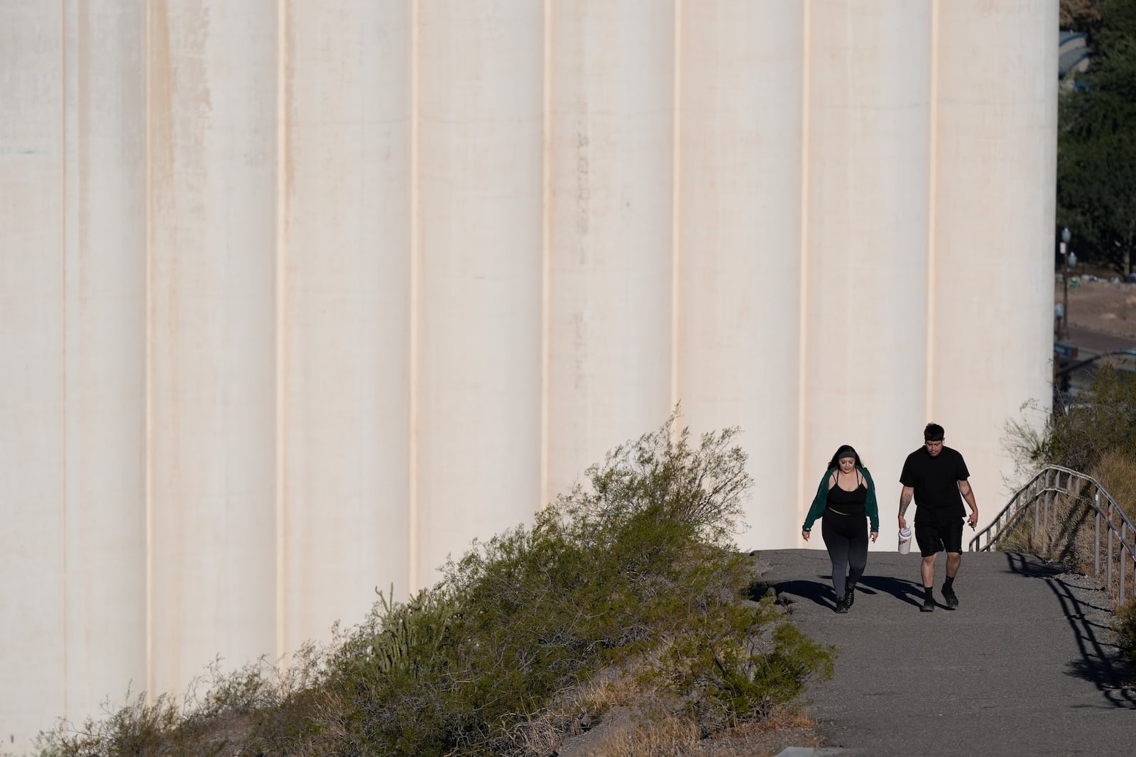 Hikers walk past the Hayden Flour Mill on thier way up "A" Mountain Tuesday, Sept. 24, 2024, in Tempe, Ariz. (AP Photo/Ross D. Franklin)