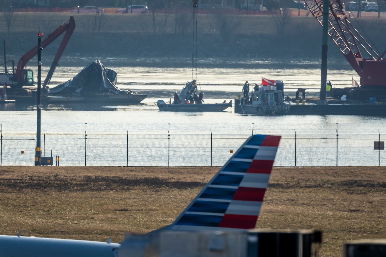 Salvage crews lift a piece of wreckage from the water at the site in the Potomac River of a mid-air collision between an American Airlines jet and a Black Hawk helicopter, at Ronald Reagan Washington National Airport, Tuesday, Feb. 4, 2025, in Arlington, Va. (AP Photo/Ben Curtis)