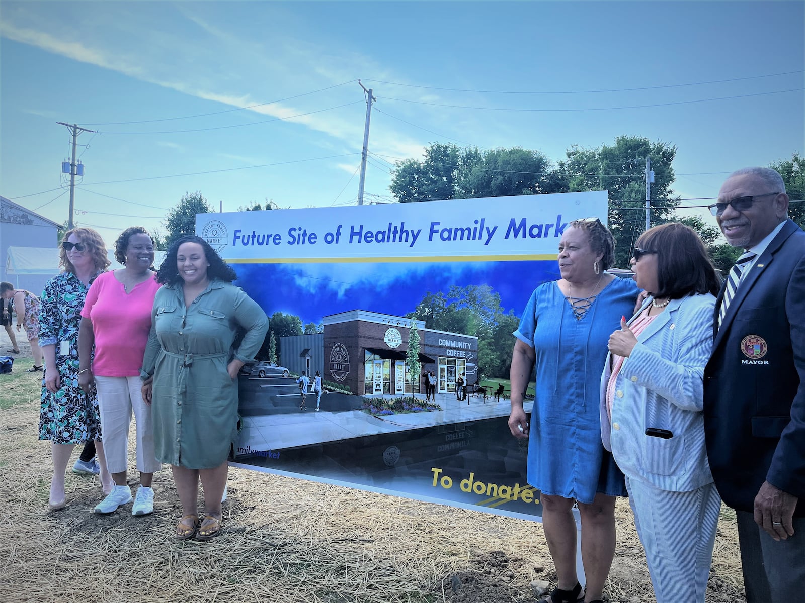 Representatives with some of the groups that partnered together on the Healthy Family Market project in West Dayton stand next to a rendering of the project during an unveiling on Friday. CORNELIUS FROLIK / STAFF